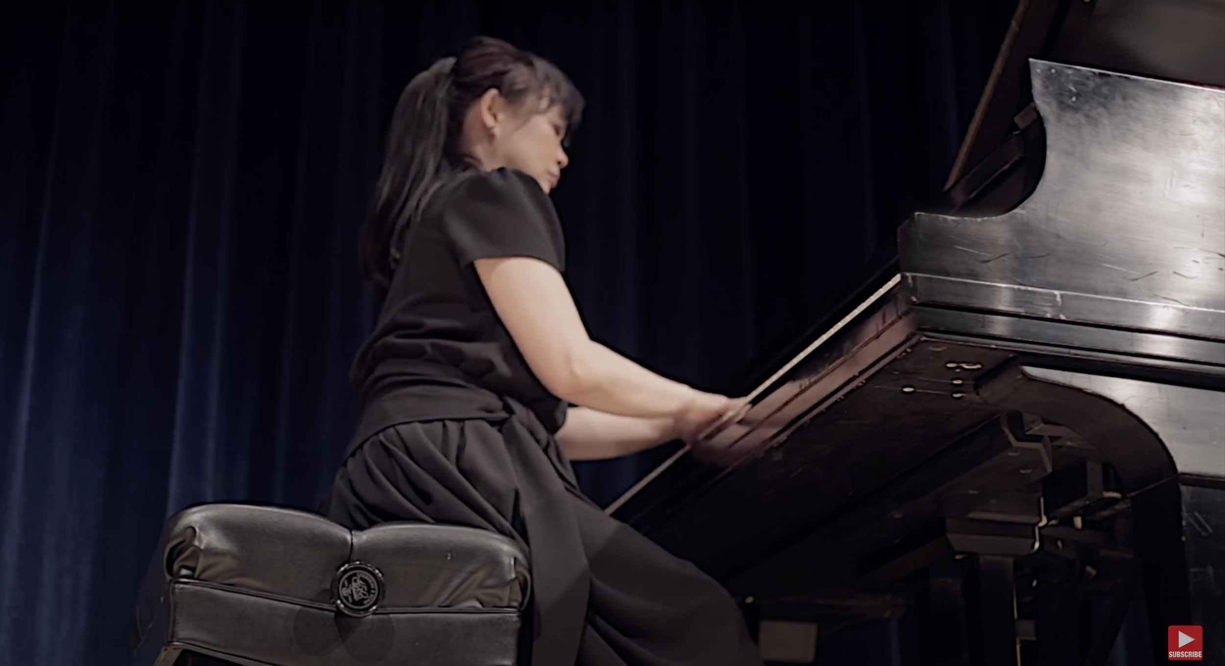 Dr. Yuking Chou Brandenburgh performing at the piano during a professional recital or masterclass.