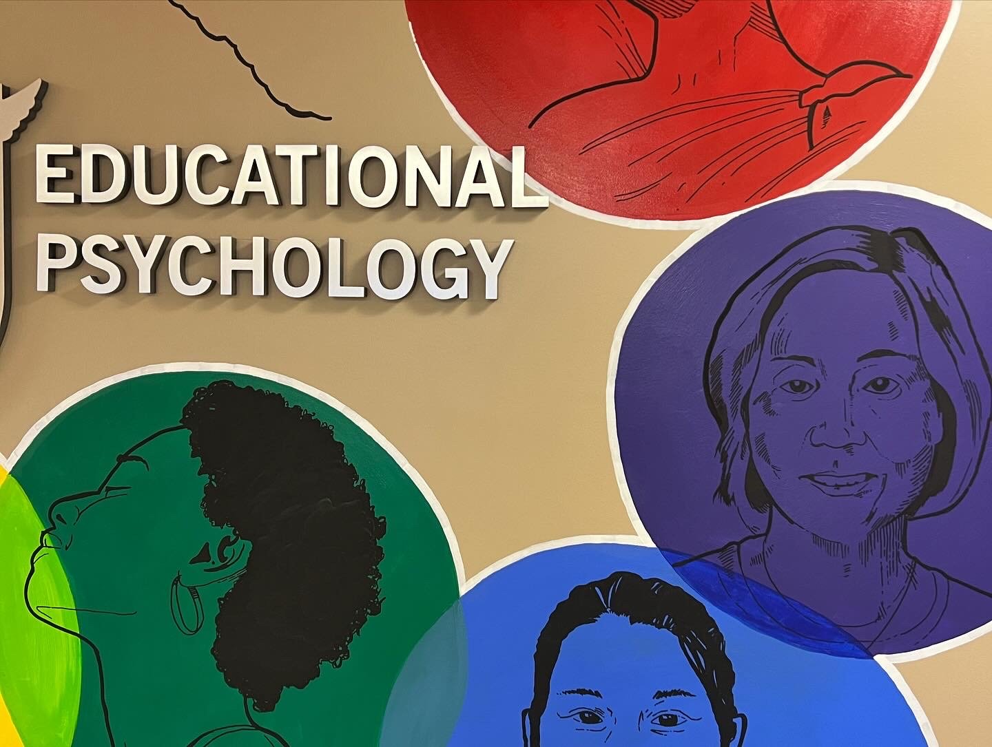 Sign for Educational Psychology with colorful illustrations of diverse individuals' faces and profile sketches.