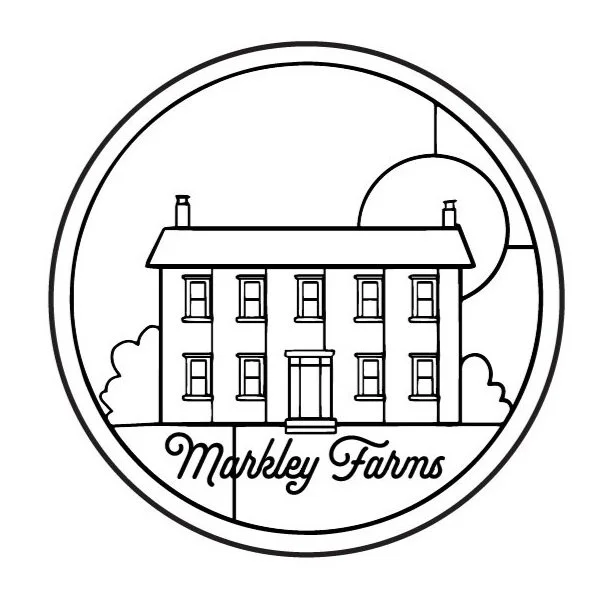 A black and white line drawing of a large farmhouse with multiple windows and a front door, surrounded by trees and enclosed in a circular border with the words 'Markley Farms' at the bottom.