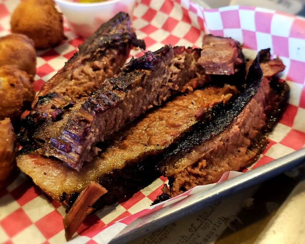 Close-up of cooked meat ribs on red and white checkered paper