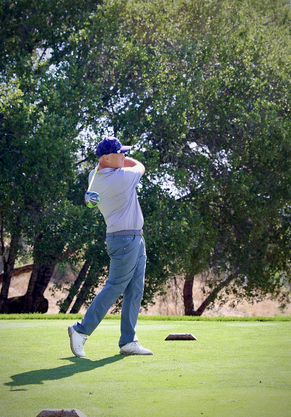 Golfer teeing off in blue hat Schulz Golf Classic