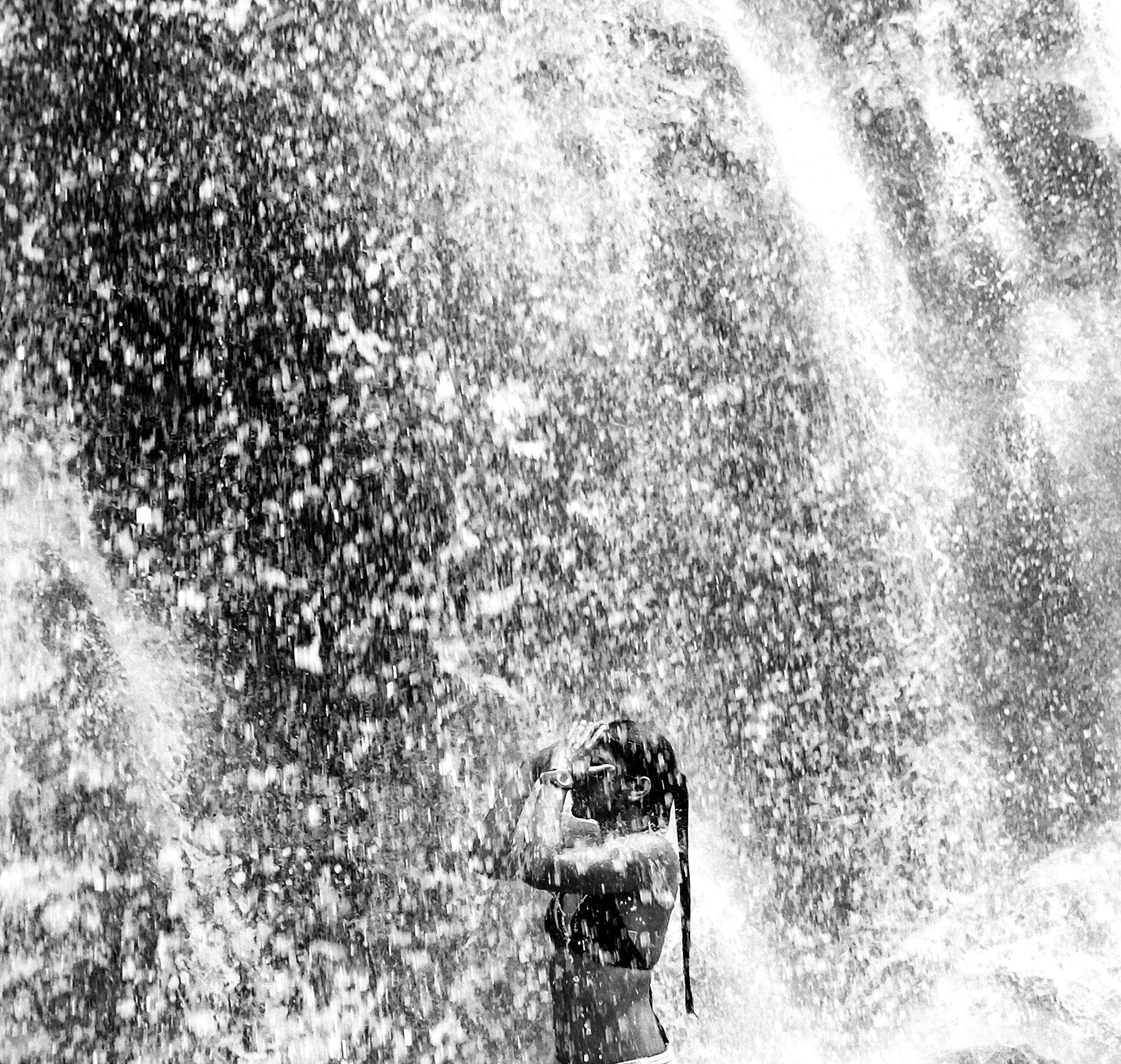 Young woman under a waterfall