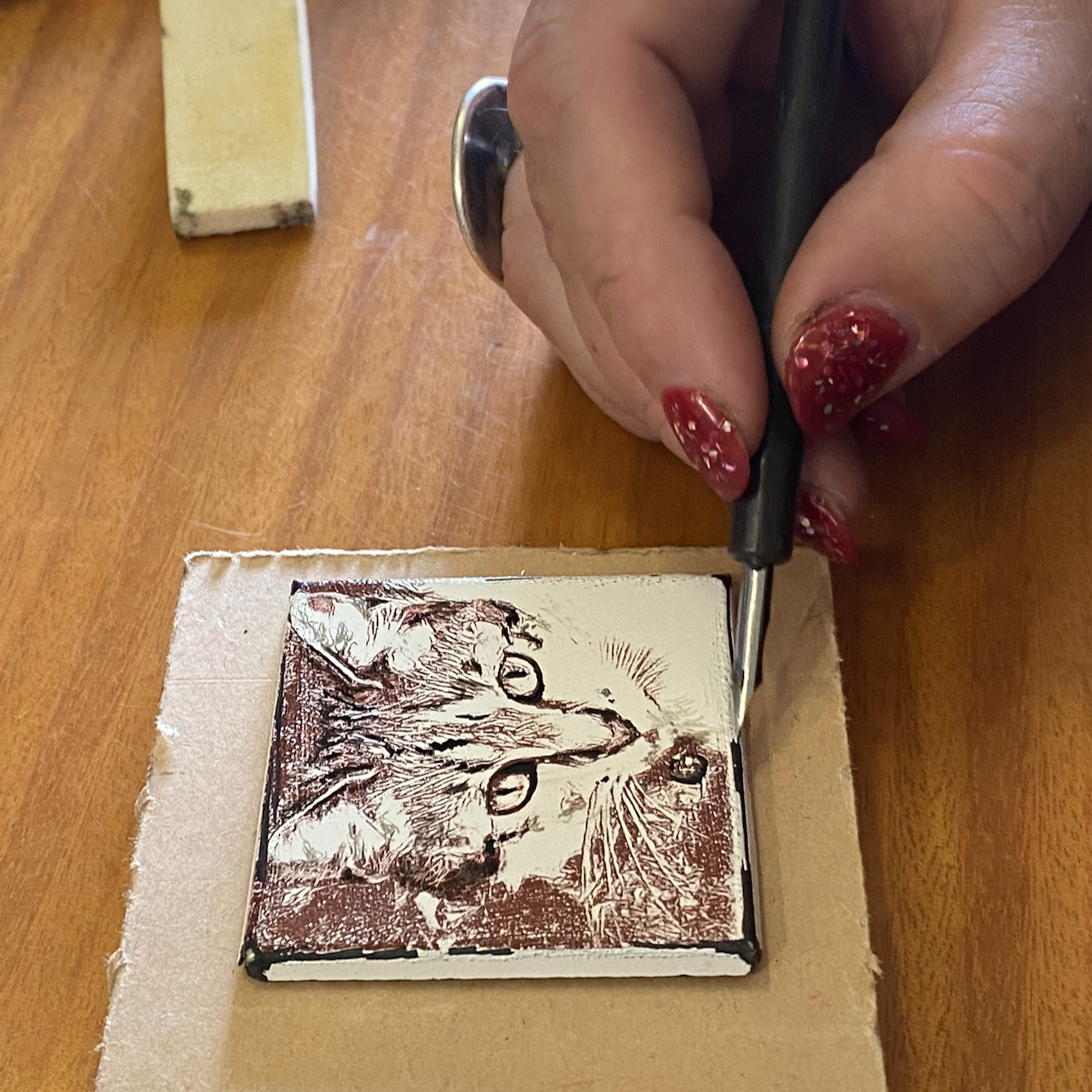 Using a crow quill nib pen to add china paint details to cat enamel decal