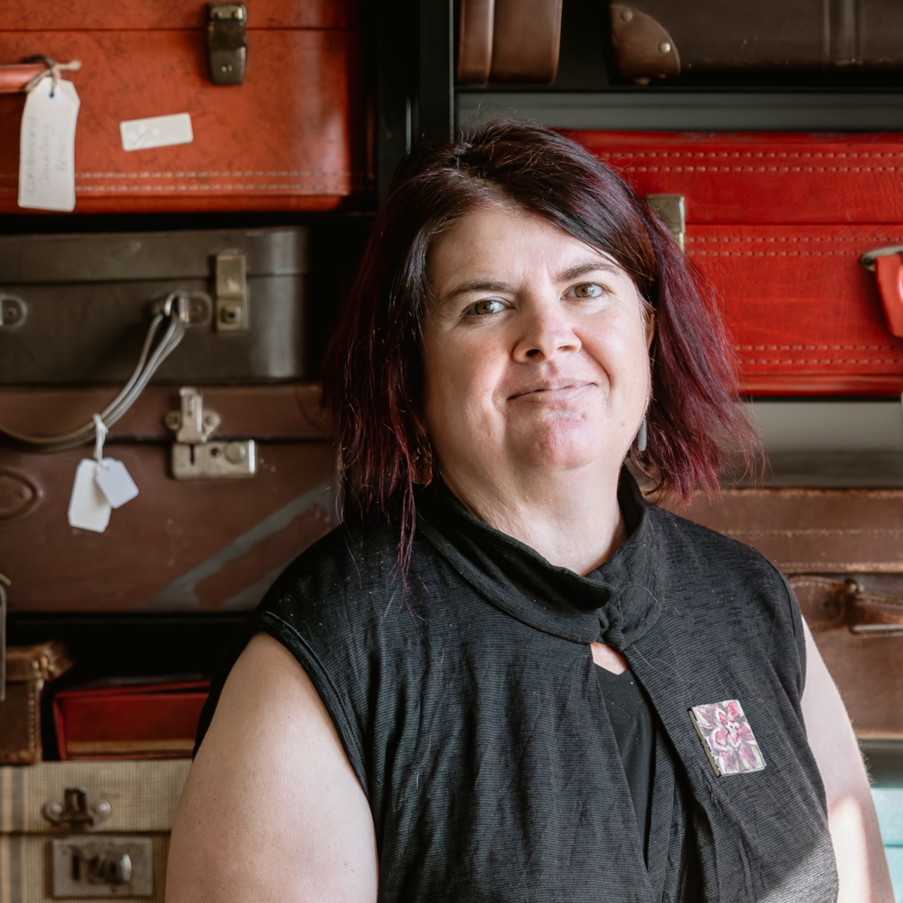 CLeed in front of her suitcase collection which is a storage feature in her studio.