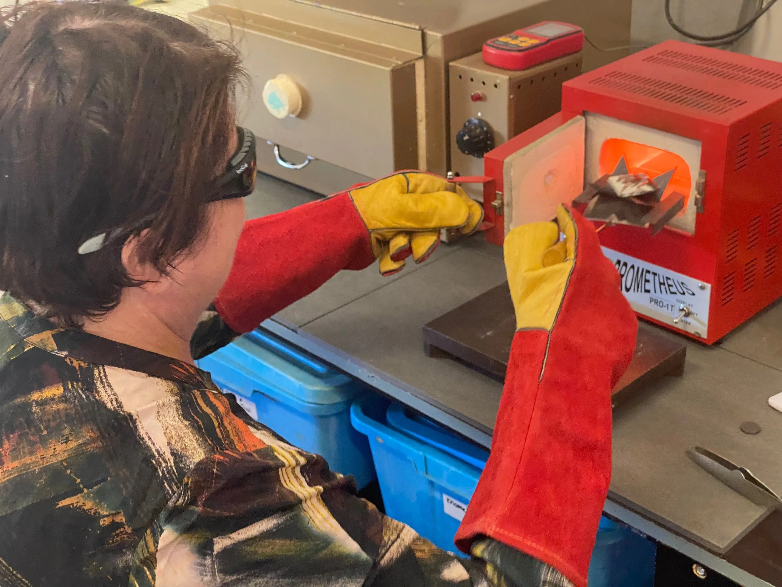Enamel artist firing a piece in a kiln