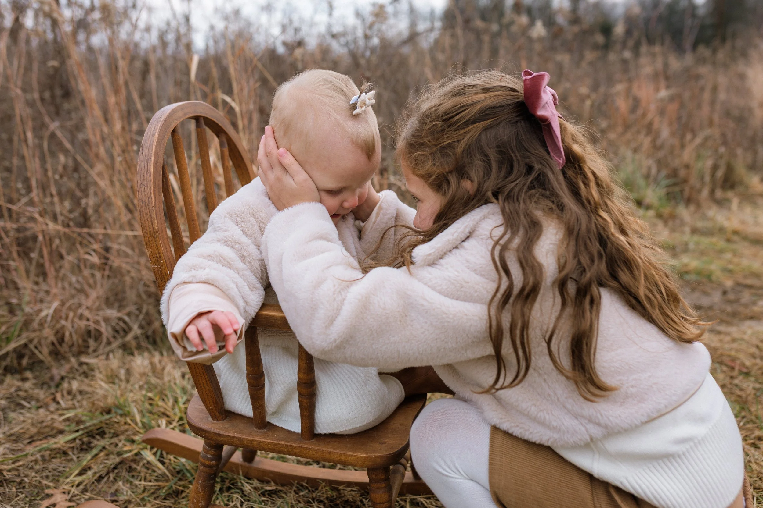 Two sisters dressed in neutral colors for a haymarket family photos.