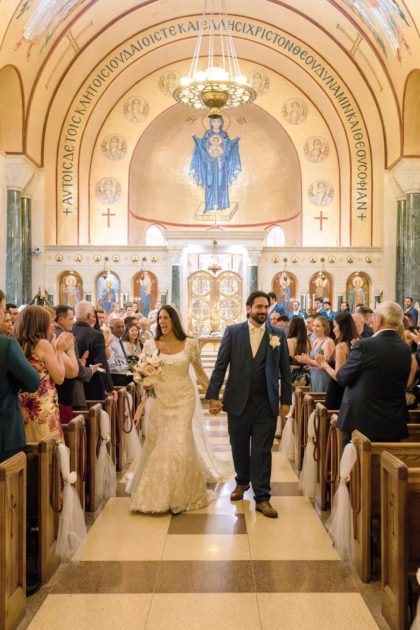 Bride and groom walking down aisle after Greek Orthodox wedding ceremony at Saint Sophia Greek Orthodox Cathedral