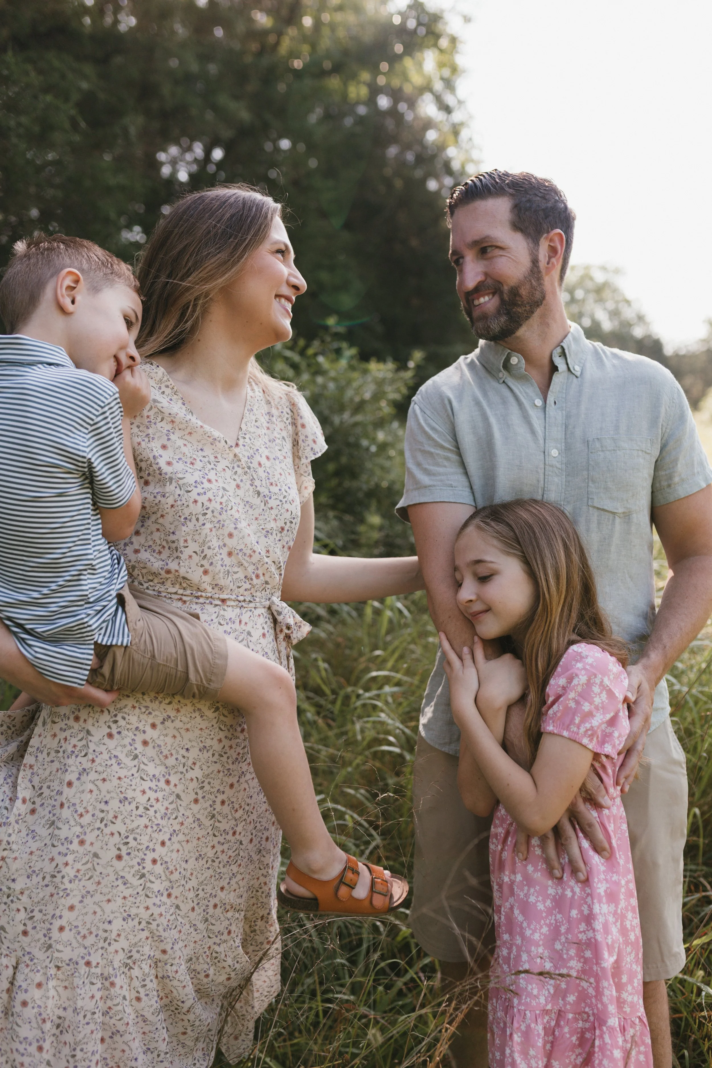 Parents and children sharing a quiet moment along a wooded path at Manassas National Battlefield Park during a natural family photography session.