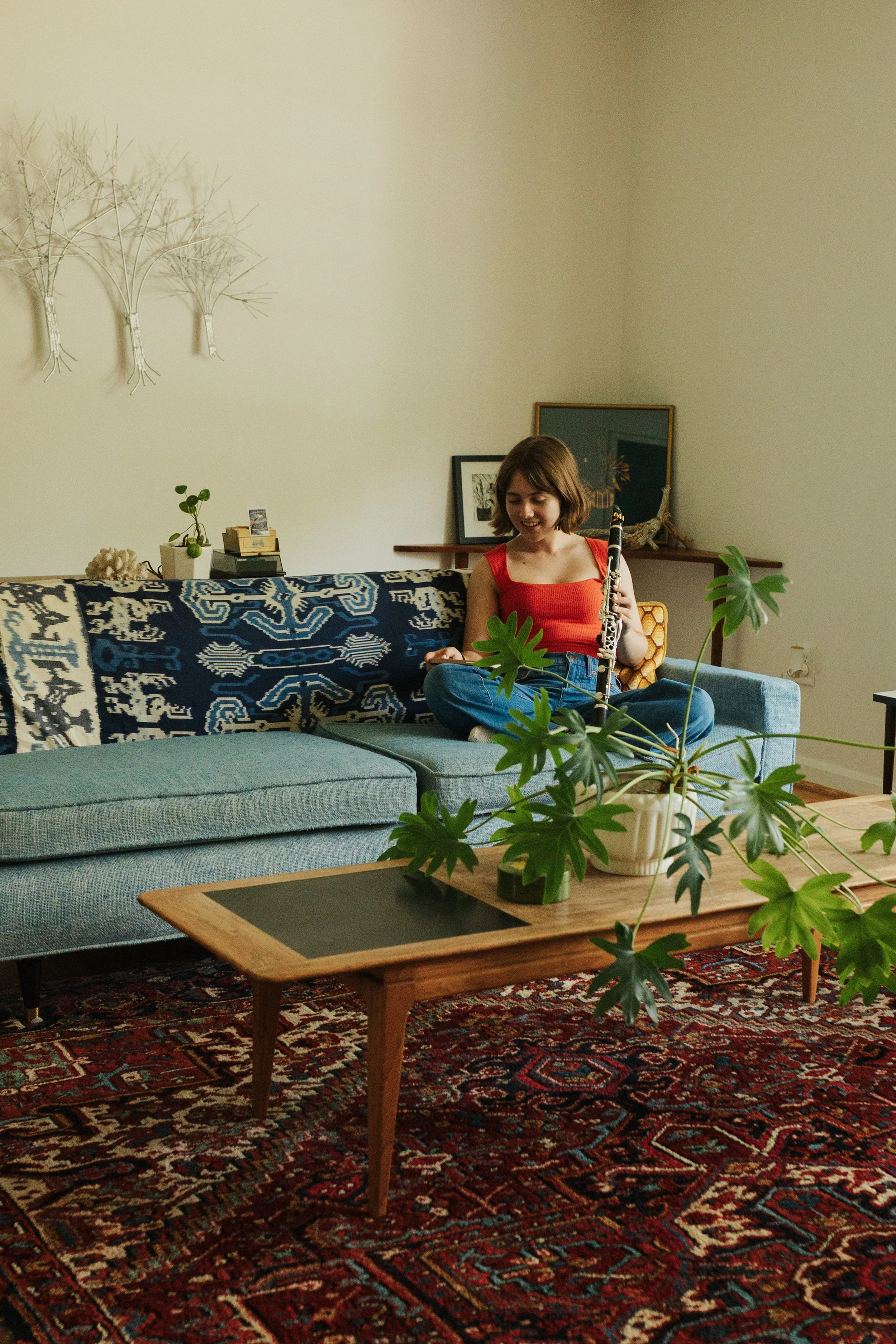West Springfield High School senior playing clarinet in a bright living room during a documentary-style senior portrait session in Fairfax County Virginia