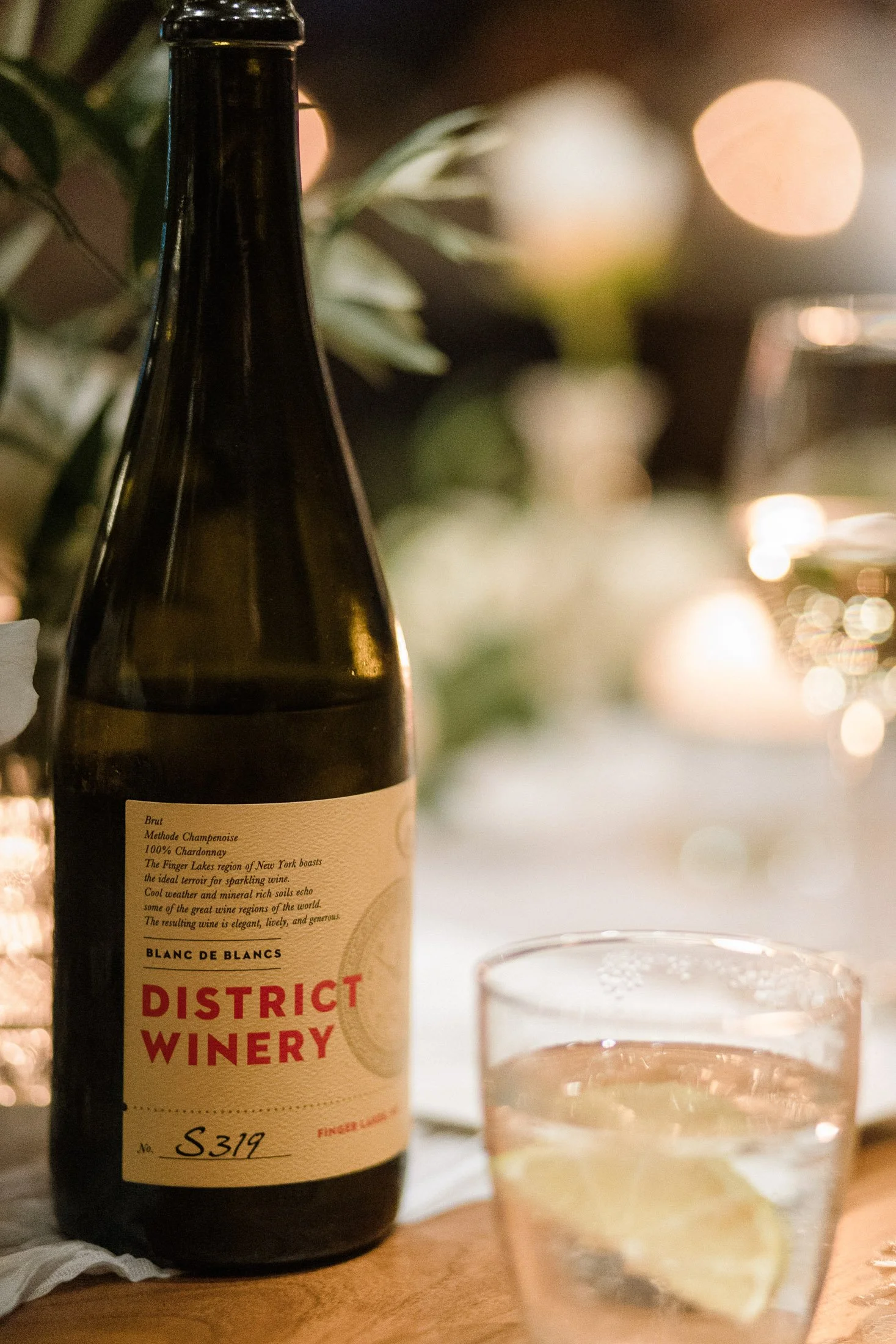 District Winery wine bottle and candlelit reception table details during Washington DC wedding