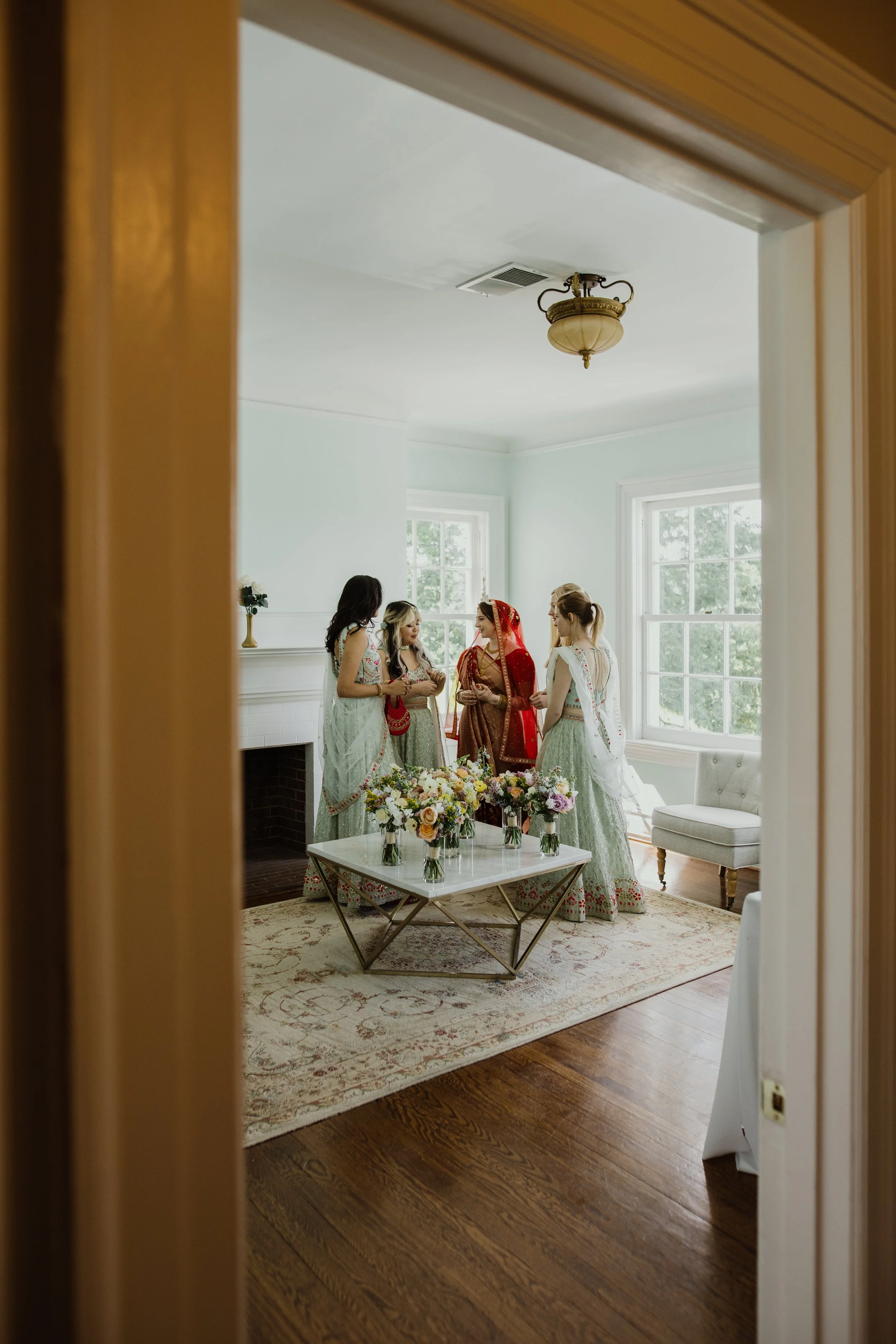 Bride and bridesmaids getting ready together inside the bridal suite at Raspberry Plain Manor in Northern Virginia.