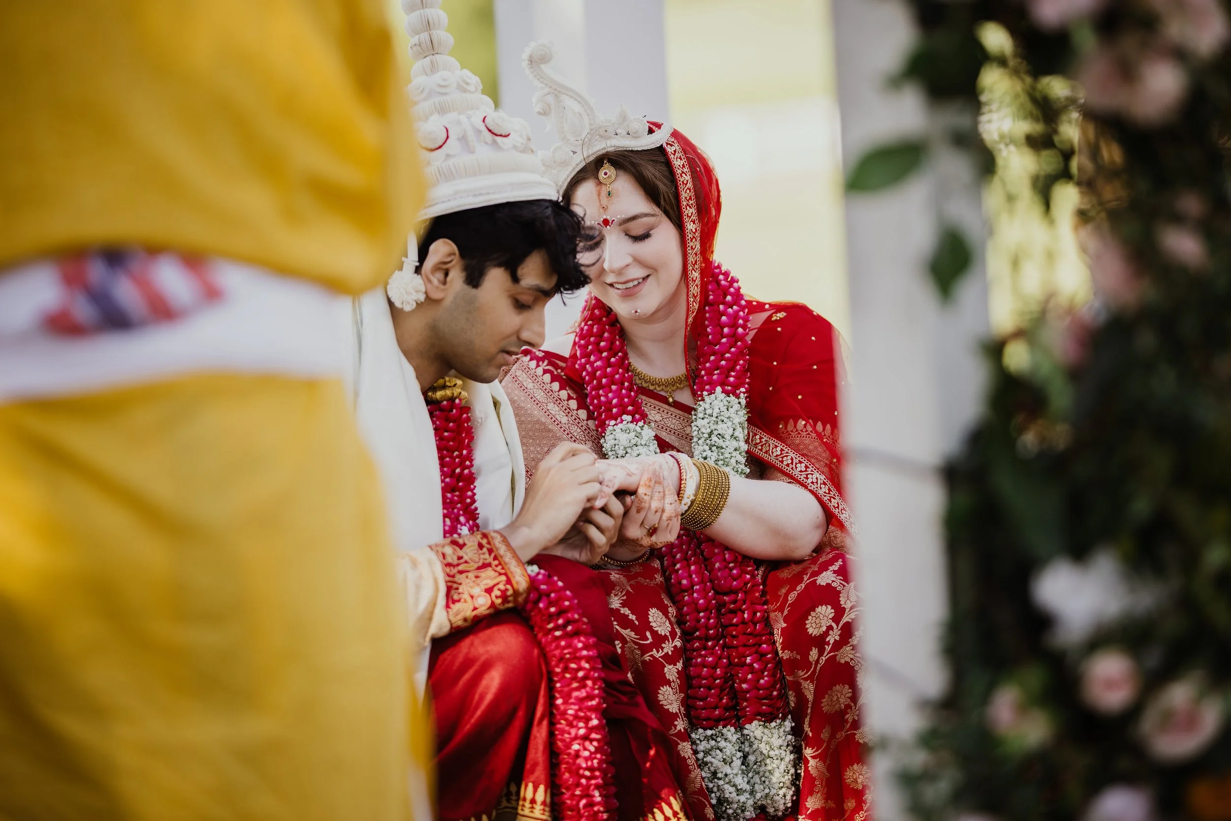 Bride and groom exchanging rings during an outdoor South Asian wedding ceremony at Raspberry Plain Manor.