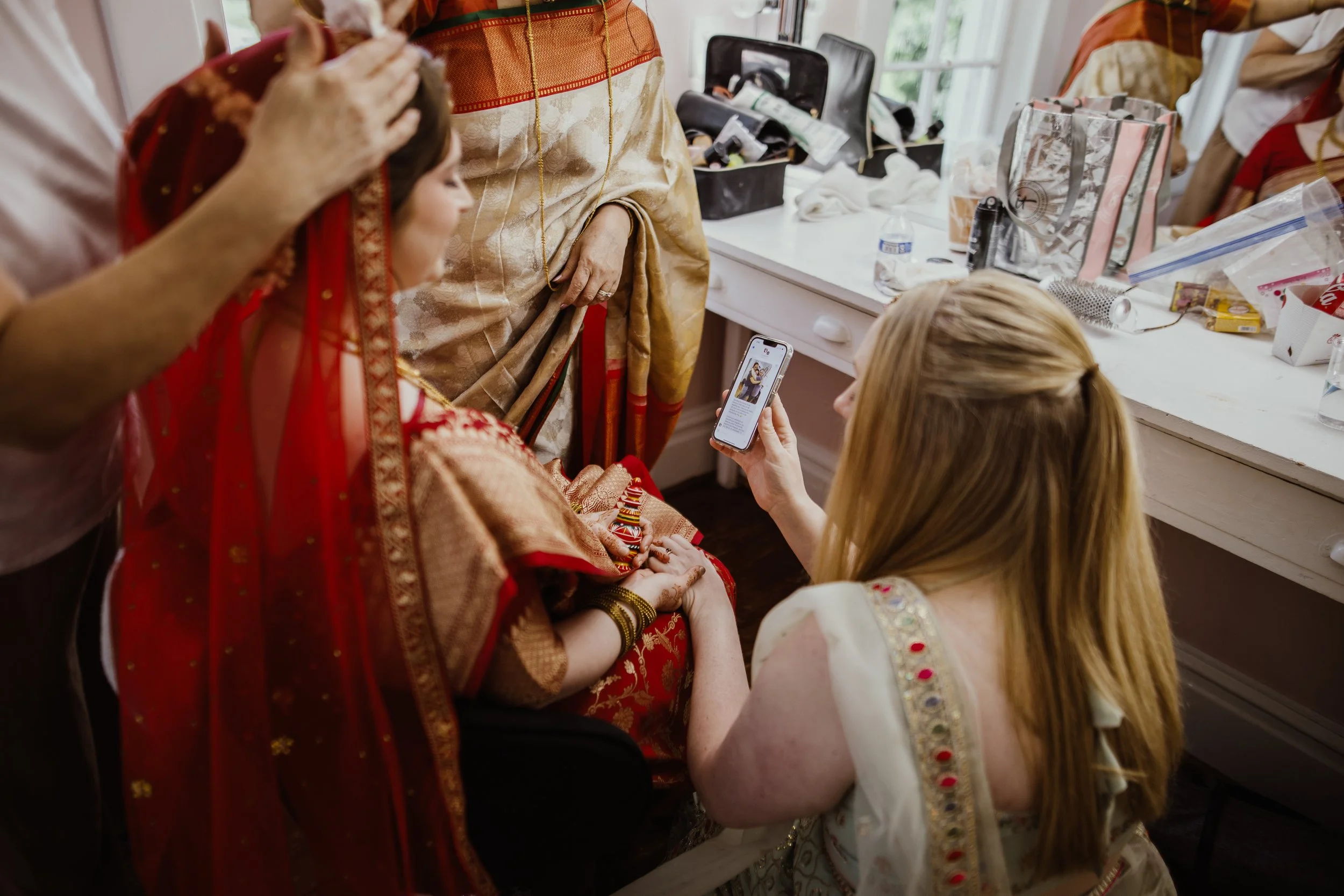 Bridesmaids helping the bride get ready before a multicultural wedding ceremony at Raspberry Plain Manor in Virginia.