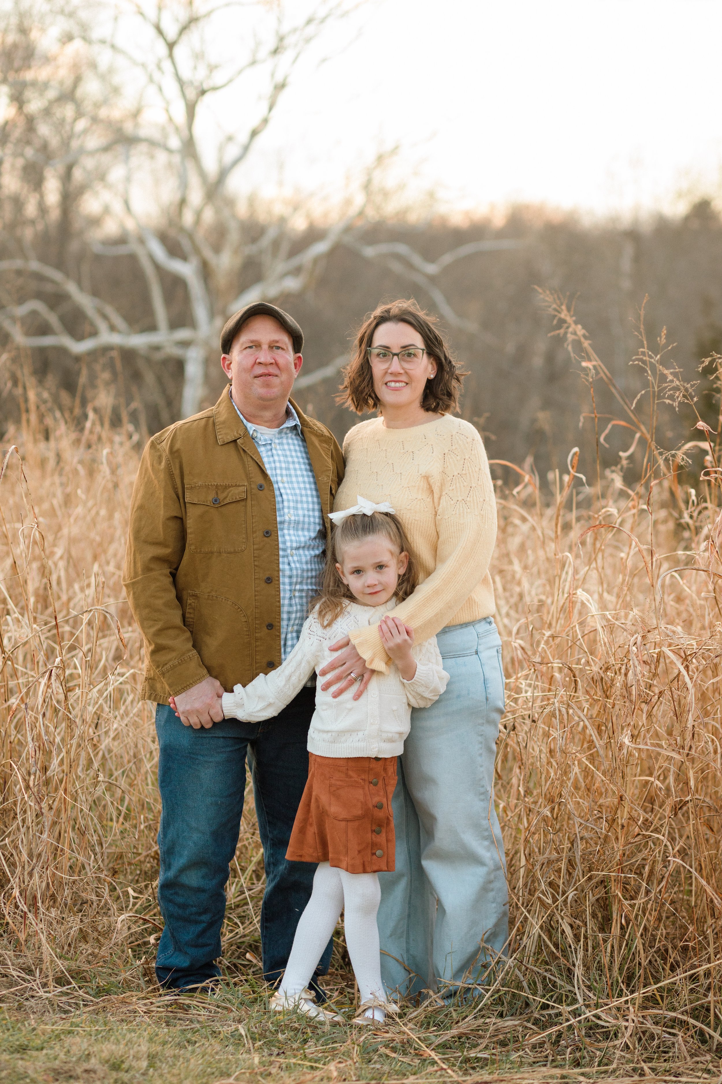 Family standing together and looking at the camera during a relaxed outdoor photography session in Northern Virginia