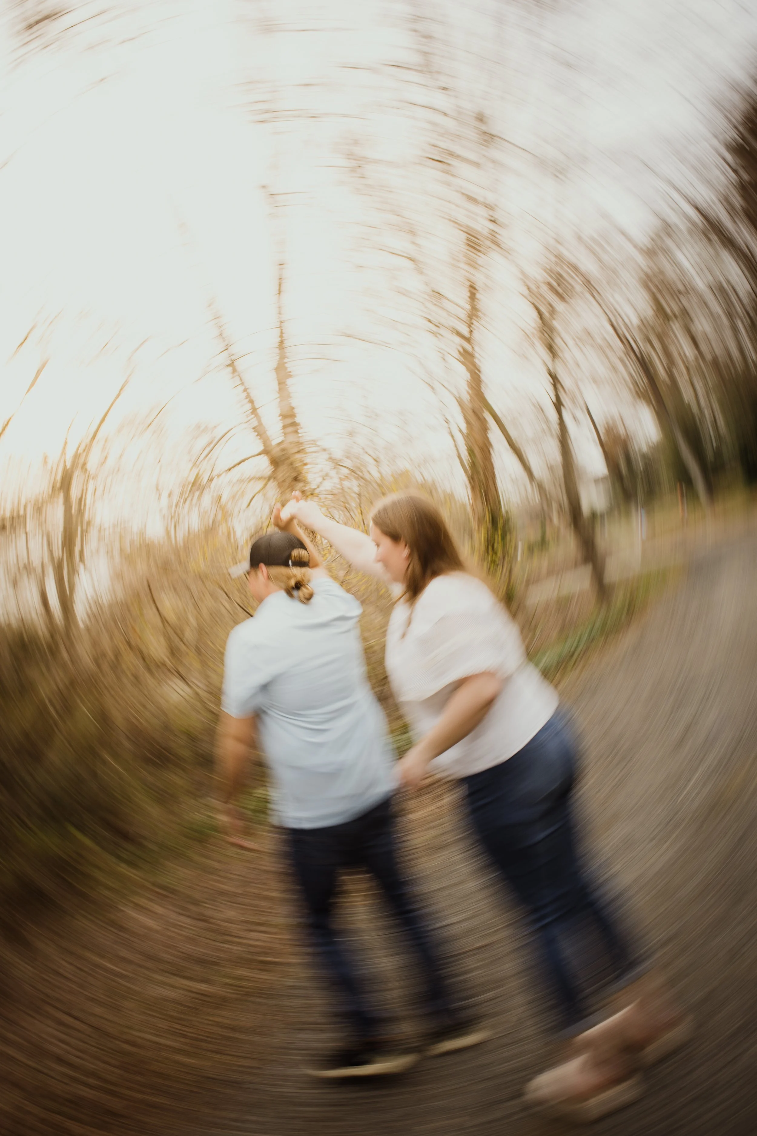 Candid engagement photo of couple laughing and spinning together during a relaxed Northern Virginia session.