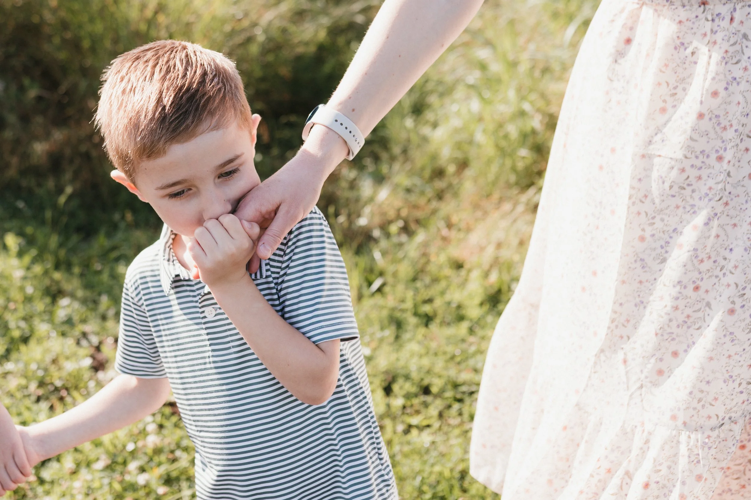 Young child holding a parent’s hand during a relaxed family photography session at Manassas National Battlefield Park.