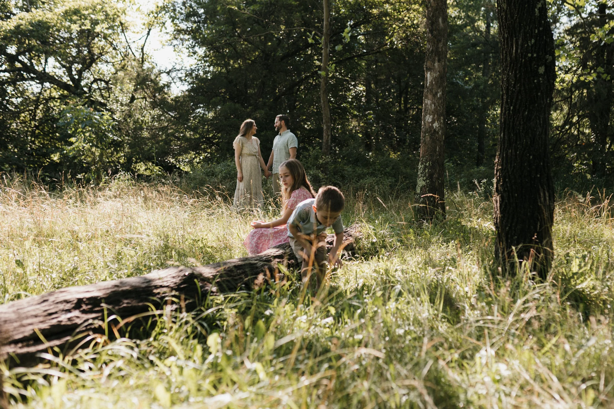 Family interacting naturally in a wooded area during a relaxed documentary-style photography session in Northern Virginia