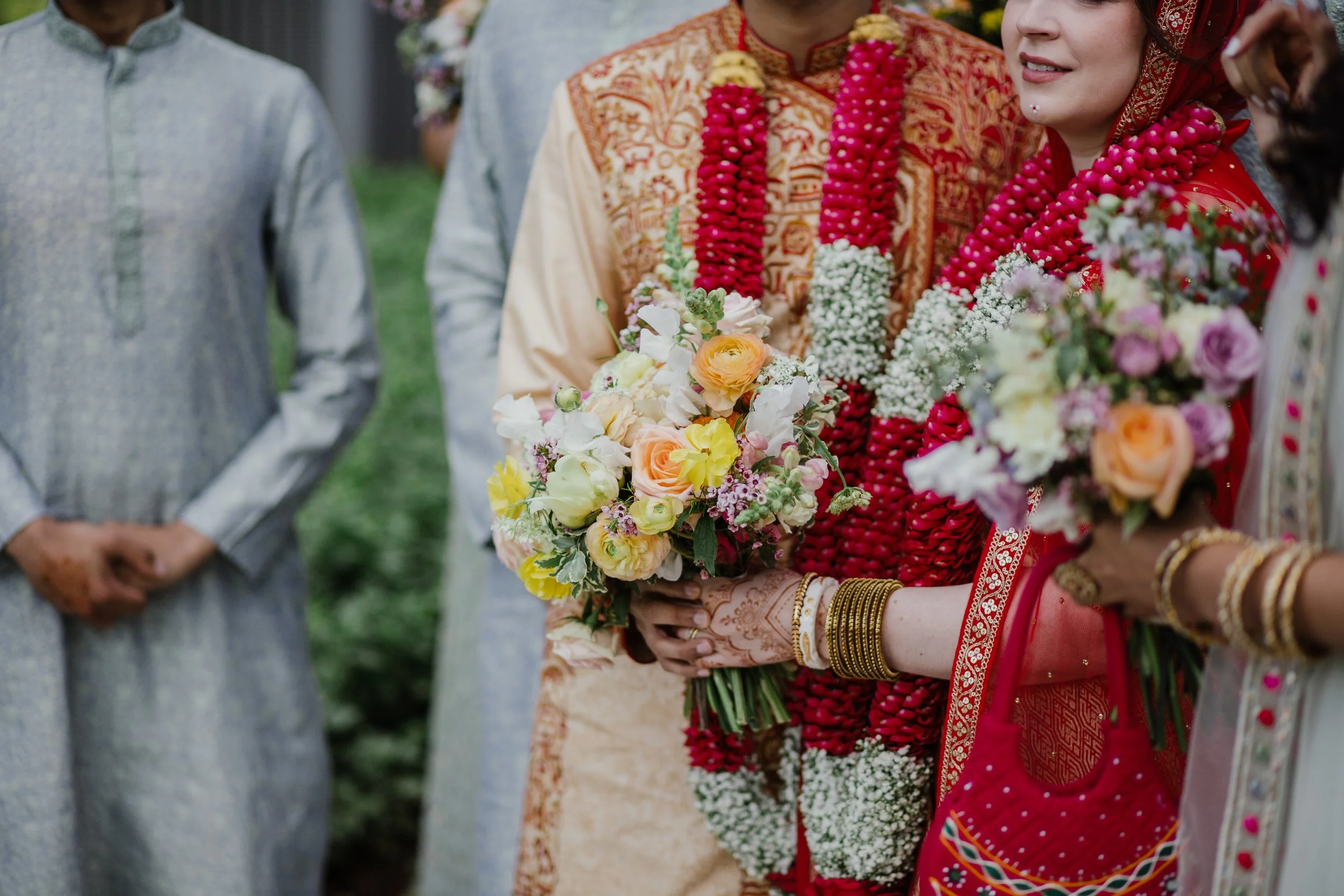 Close-up of colorful bridal bouquets and floral garlands during a South Asian wedding celebration in Northern Virginia.