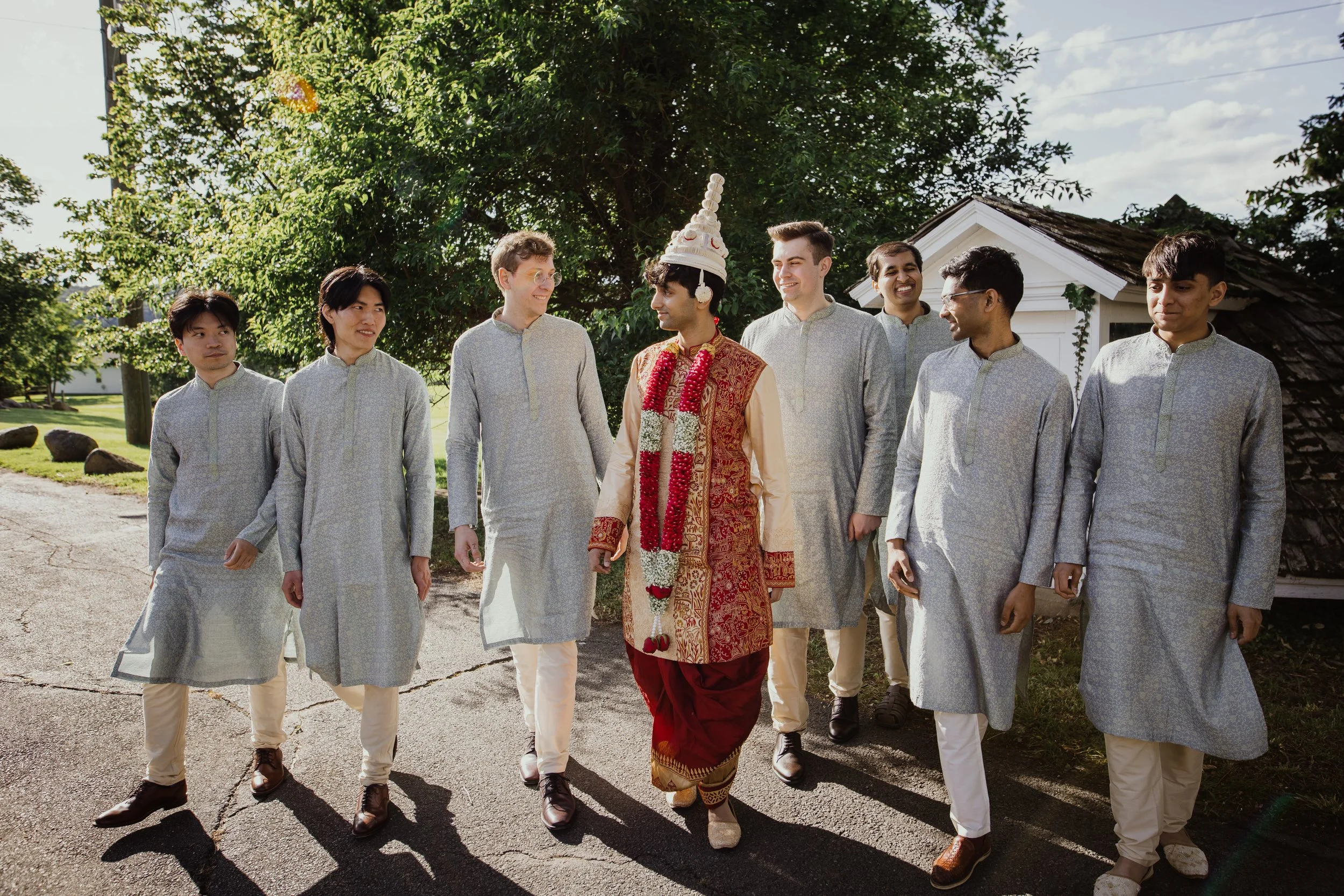 Groom walking with groomsmen before a South Asian wedding ceremony at Raspberry Plain Manor.