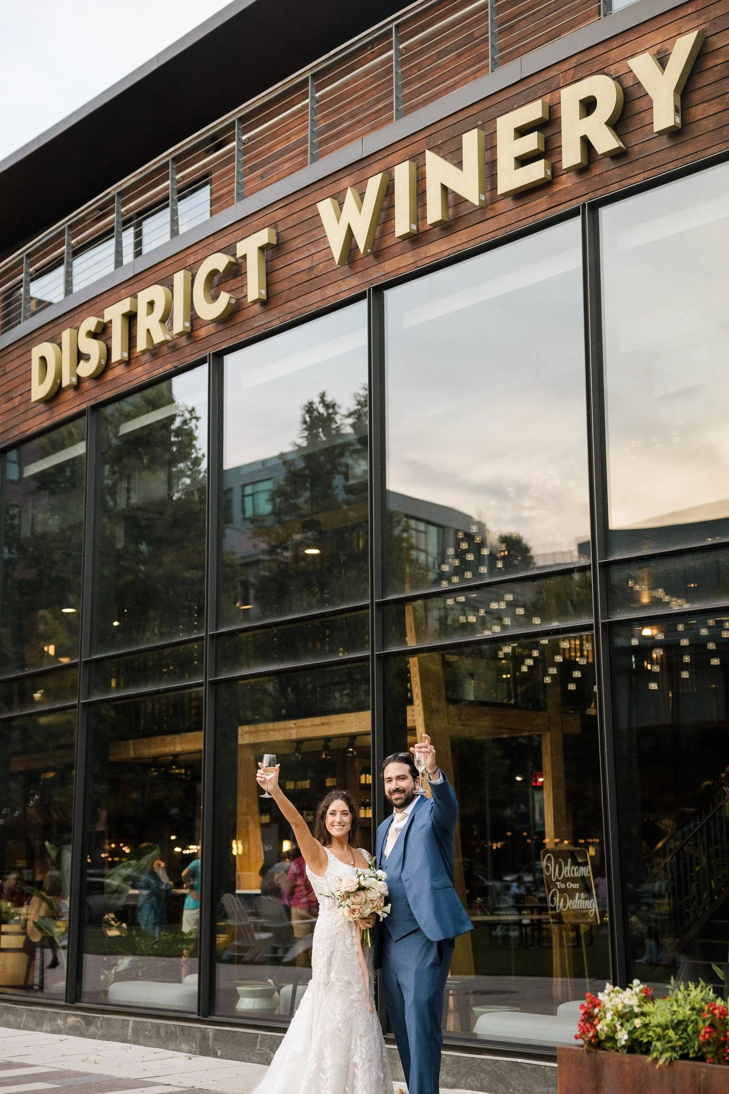 Bride and Groom toasting under the District Winery sign in Washington DC