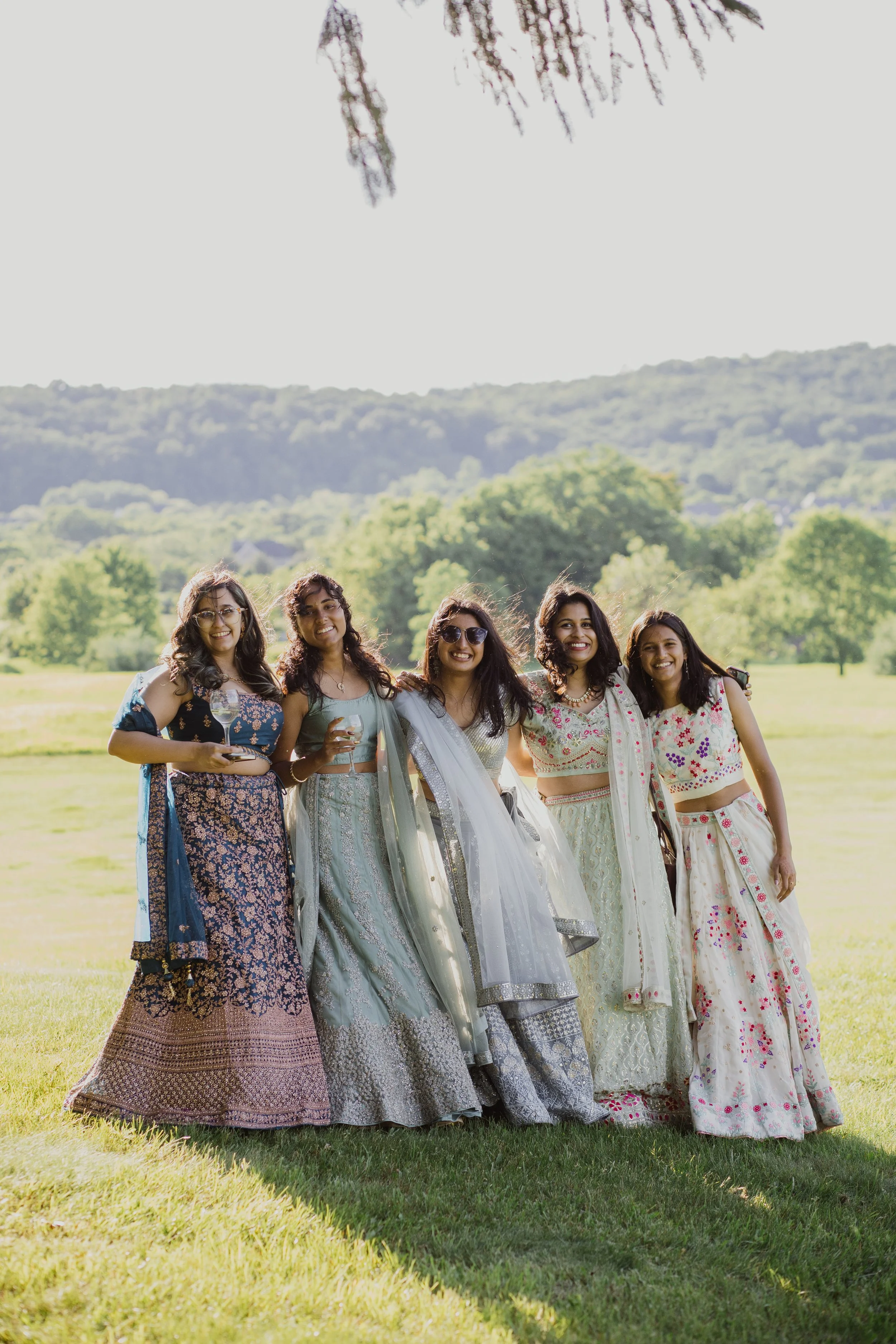 Wedding guests in colorful traditional attire posing outdoors at Raspberry Plain Manor in Leesburg, Virginia during a multicultural wedding celebration.