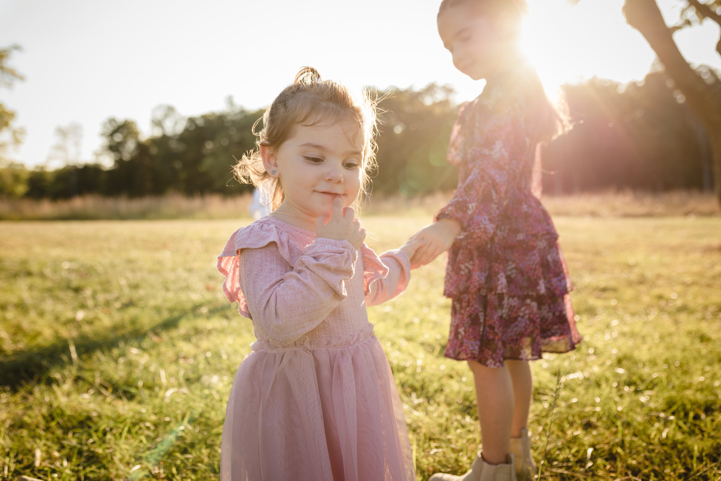 Children walking through a sunlit field during a golden hour family photography session in Northern Virginia