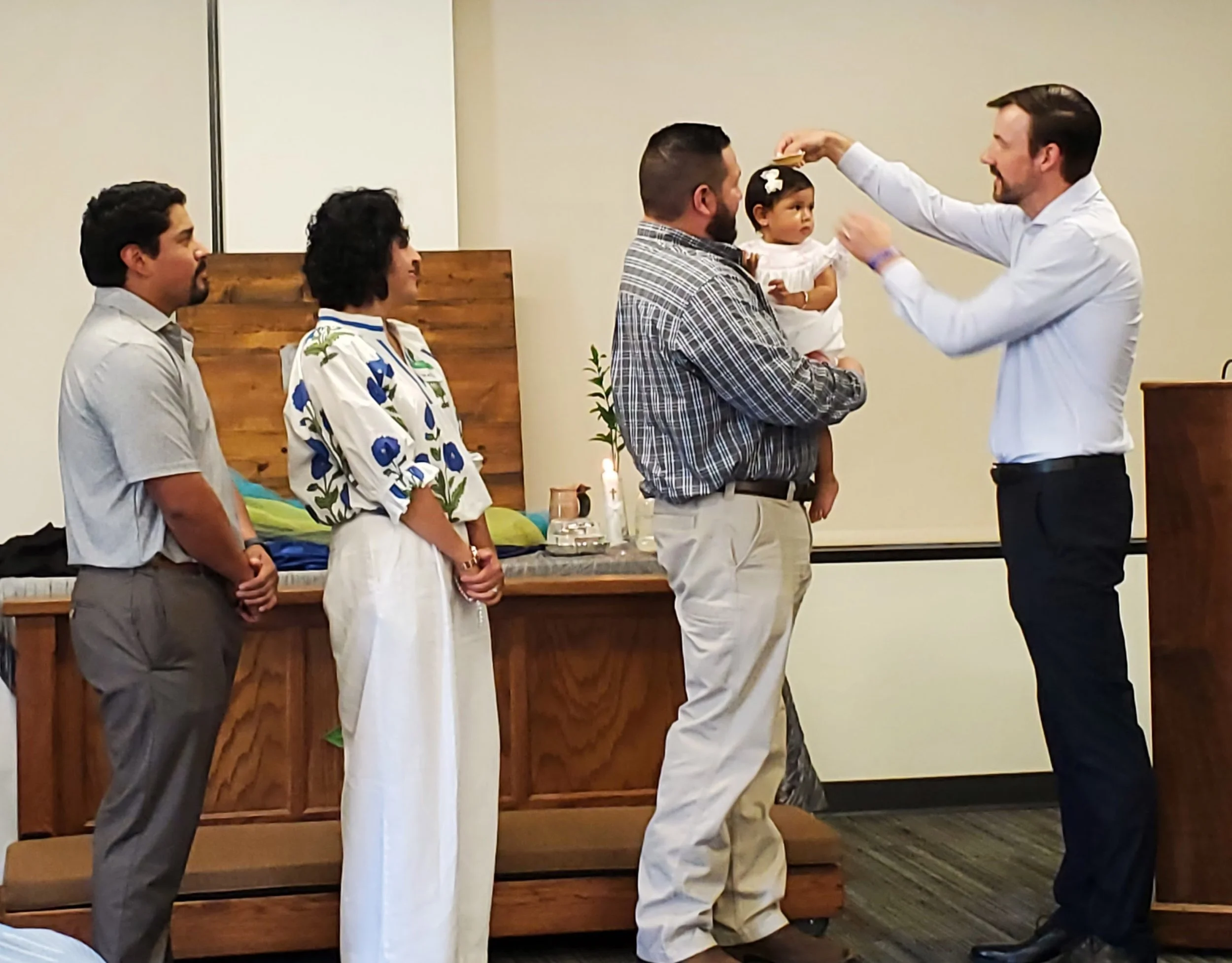A wedding ceremony with four men and a young girl, where one man is placing a ring on a young girl's finger held by another man.