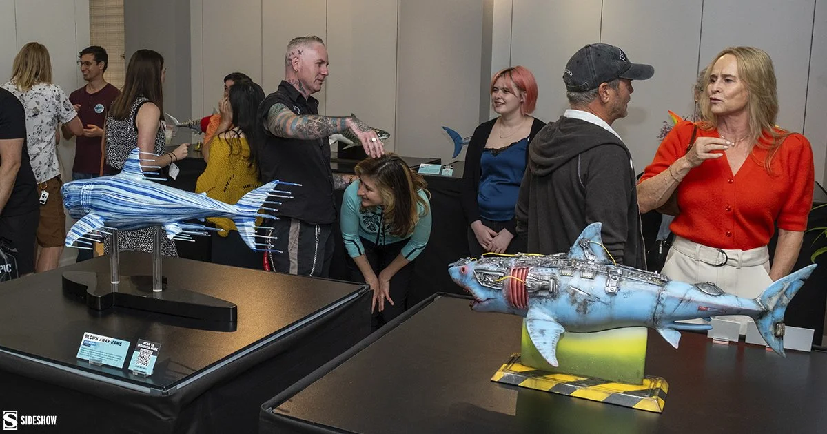 Gallery-attendants-gather-and-converse-around-the-podiunms-showcasing-shark-pieces-at-Jumping-the-Shark.jpg