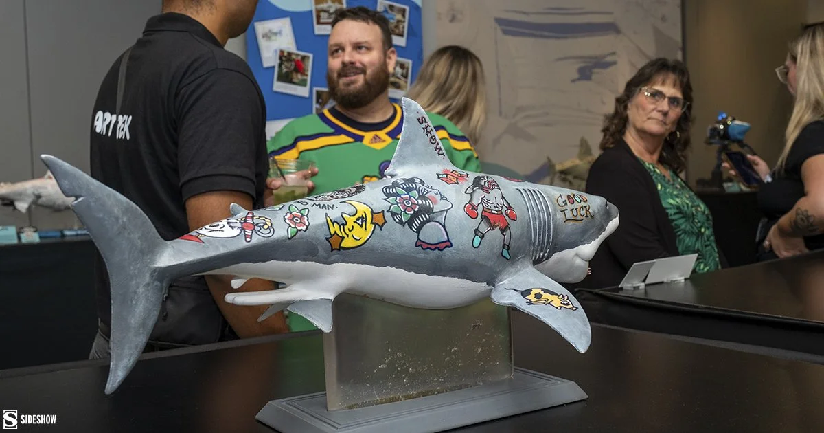 A-close-up-shot-of-Vinh-Luongs-tattooed-shark-with-people-conversing-in-the-background.jpg