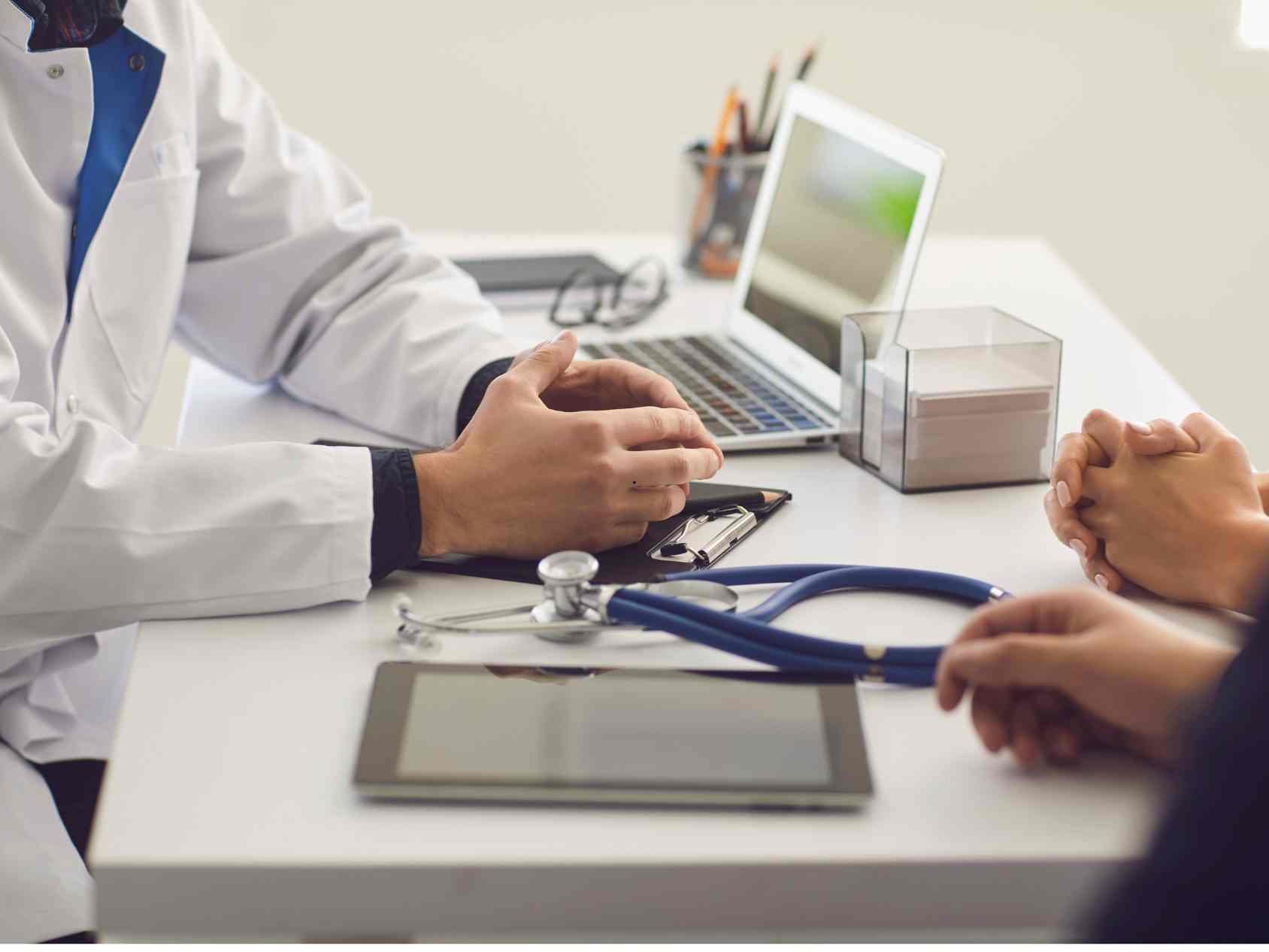 Woman at desk with doctor