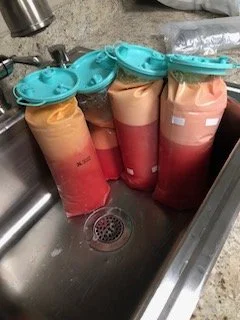 kitchen sink with bags of breast milk in teal-capped storage bags