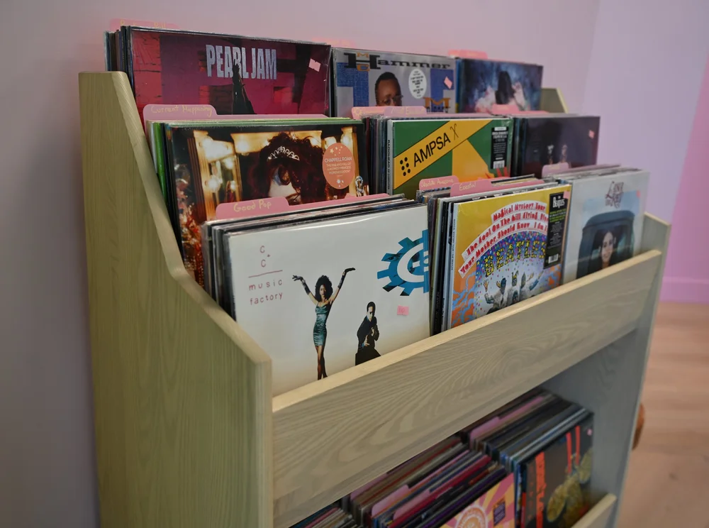Racked records and books on a low shelf in the shop at The Awoken Space