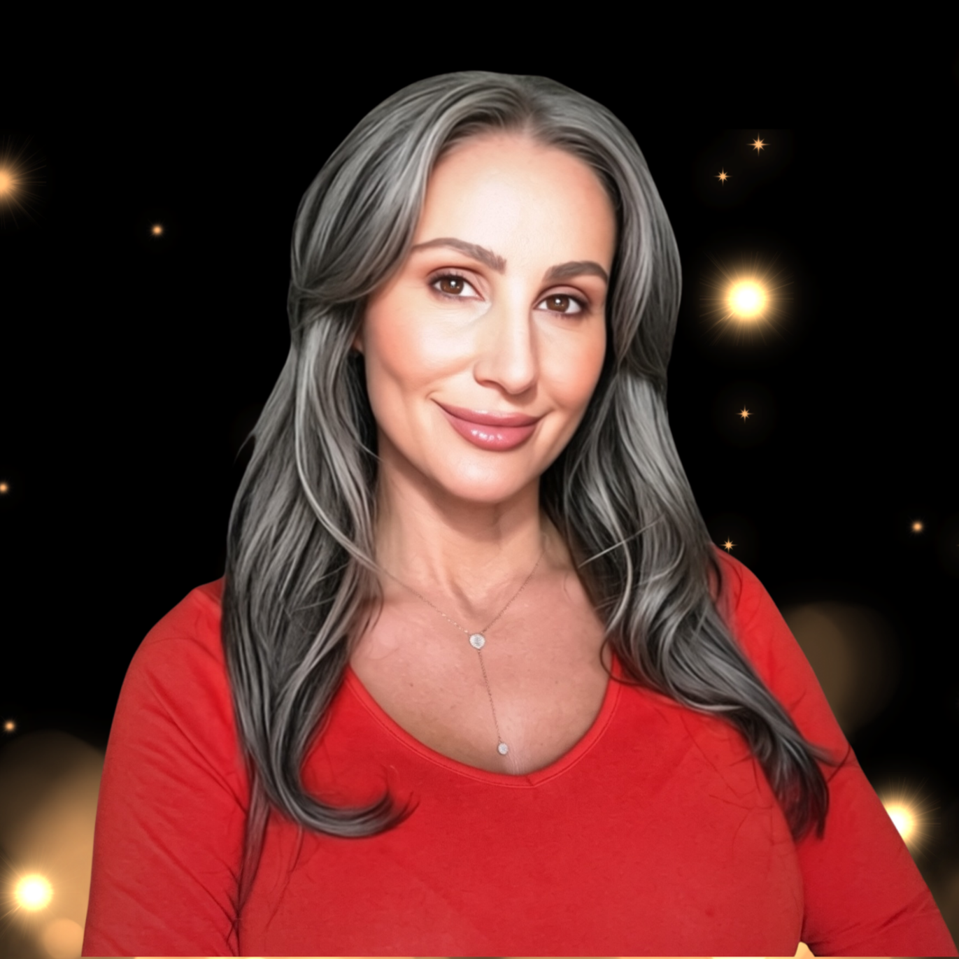 A woman with long gray hair smiling, wearing a red top and a delicate necklace, against a dark background with glowing star-like lights.