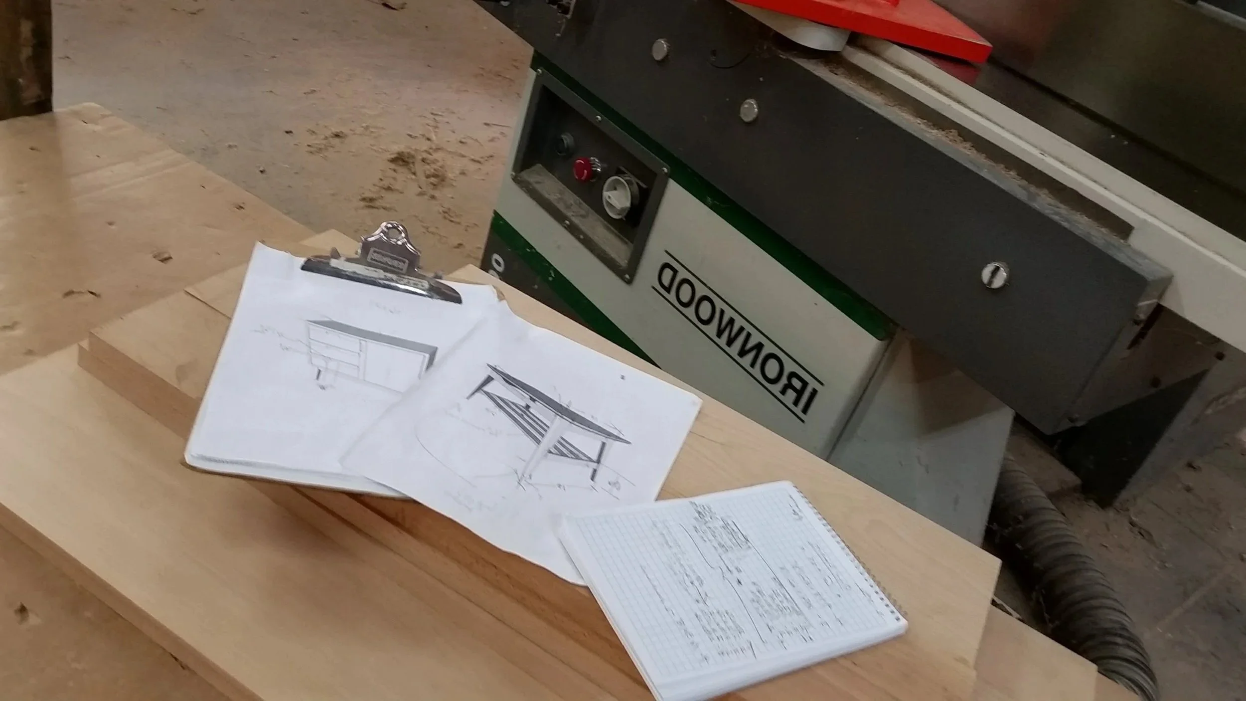 Renderings of custom designed furniture along side cut list on cart in woodshop