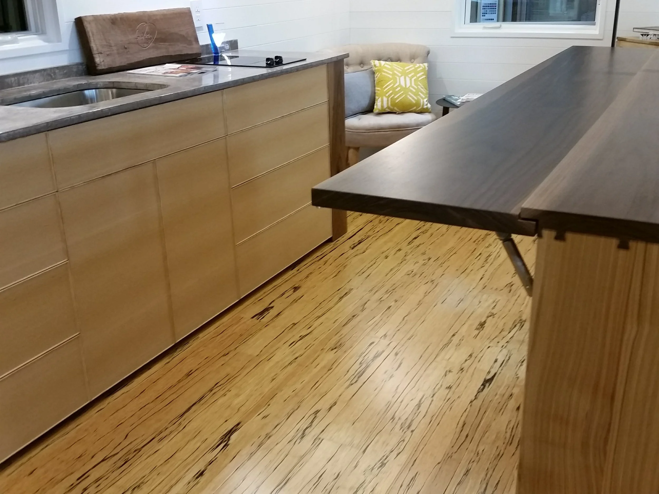 Modern veneered cabinetry featuring quarter sawn ash and beaded fronts installed in tiny home with solid walnut top detailing through dovetail joinery.