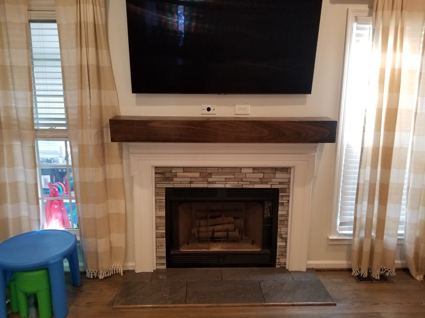 View of a compact fireplace with the flat screen tv above. The width of the tv is aligned with the width of the fireplace. 