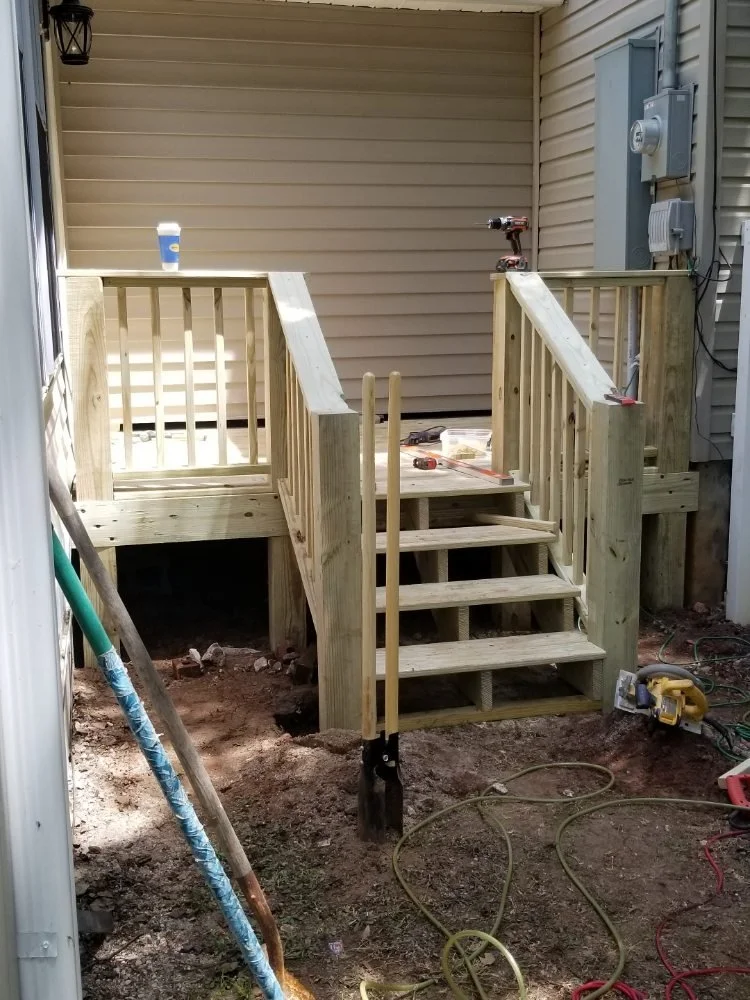 View of small deck built between two exterior walls in the backyard. 