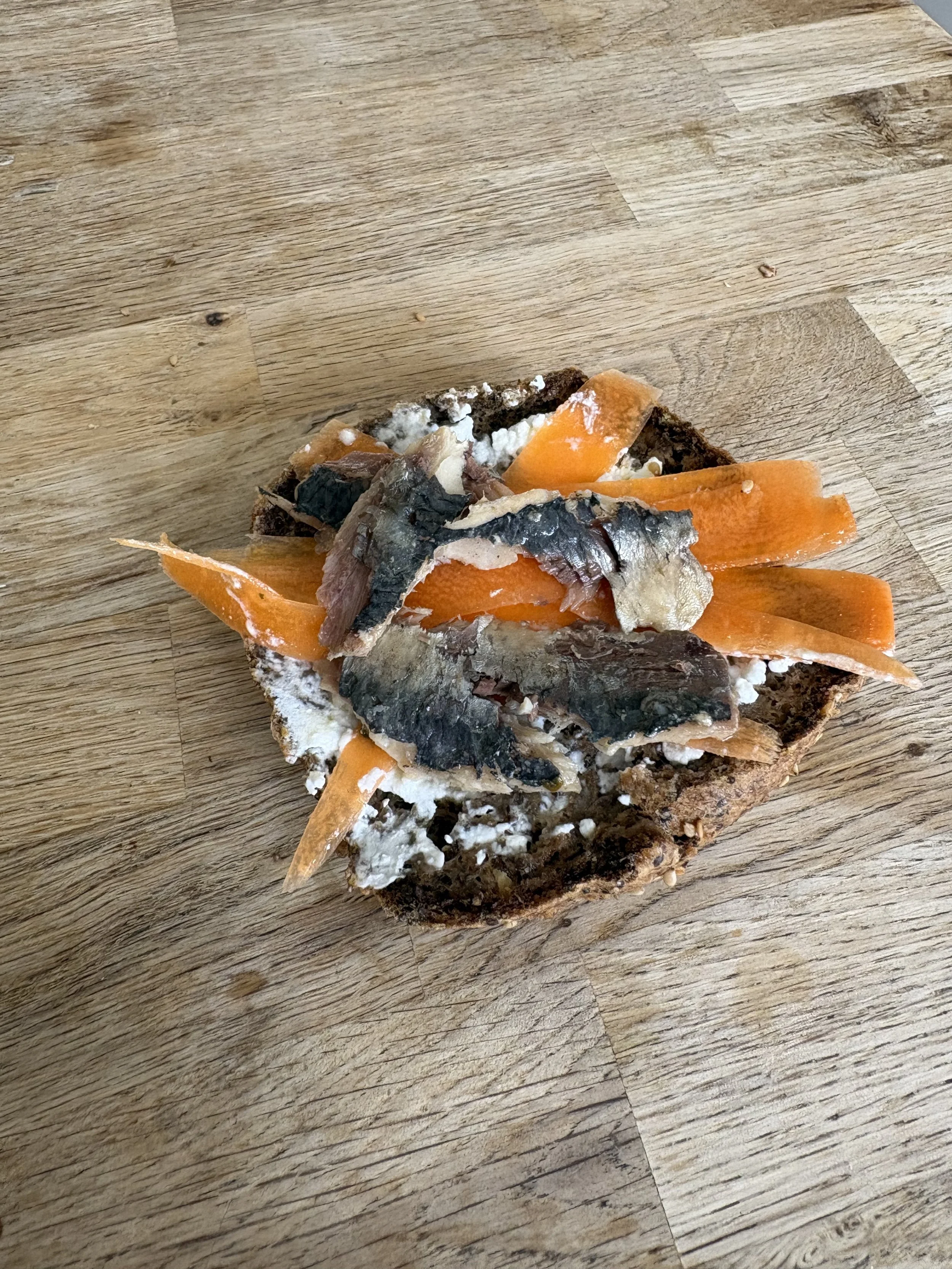 Intérieur du bun de lentilles corail garni de yaourt, sardines au citron et carottes, riche en vitamine A pour une belle peau