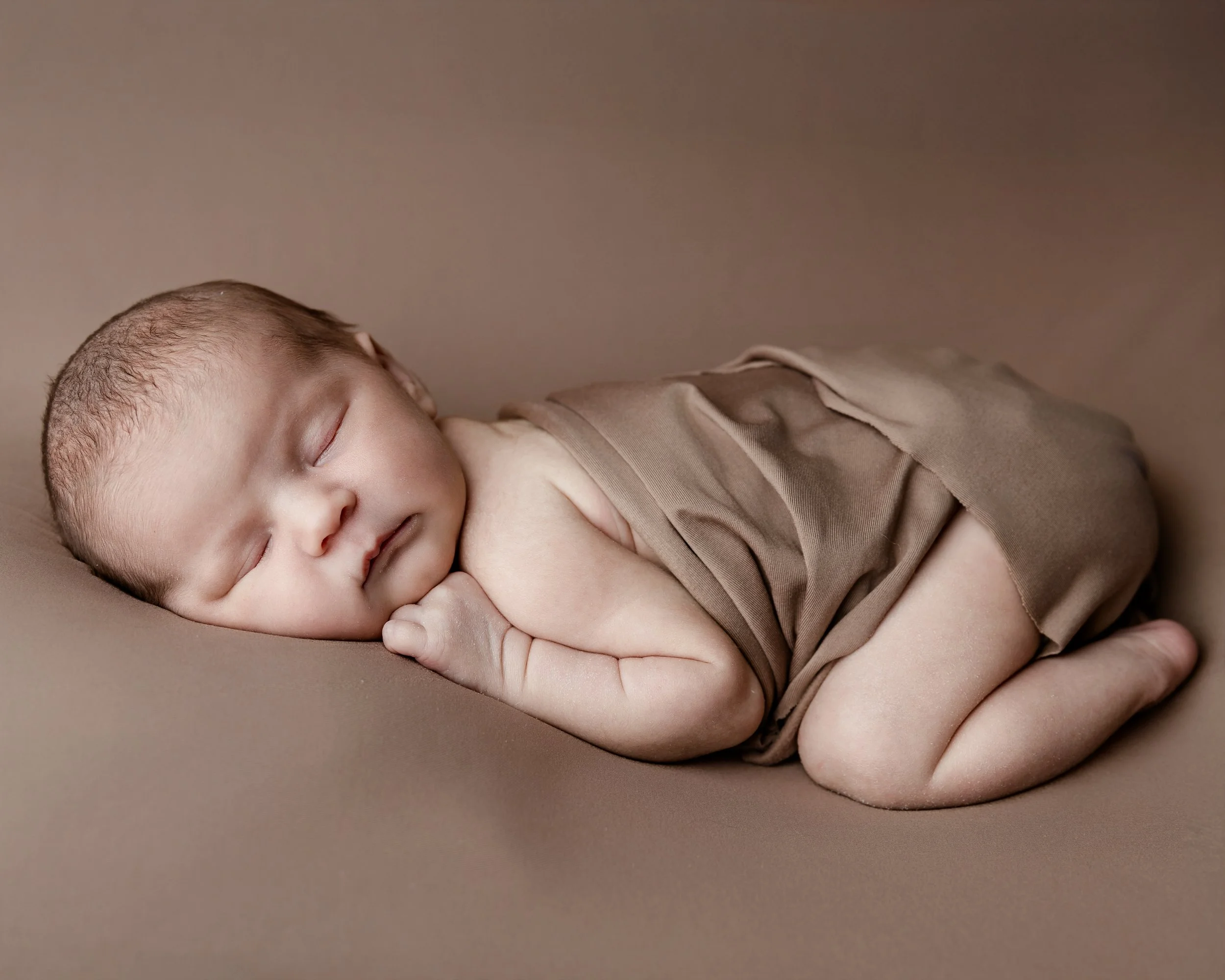 babyfoto-baby på magen-brun bakgrunn.jpeg