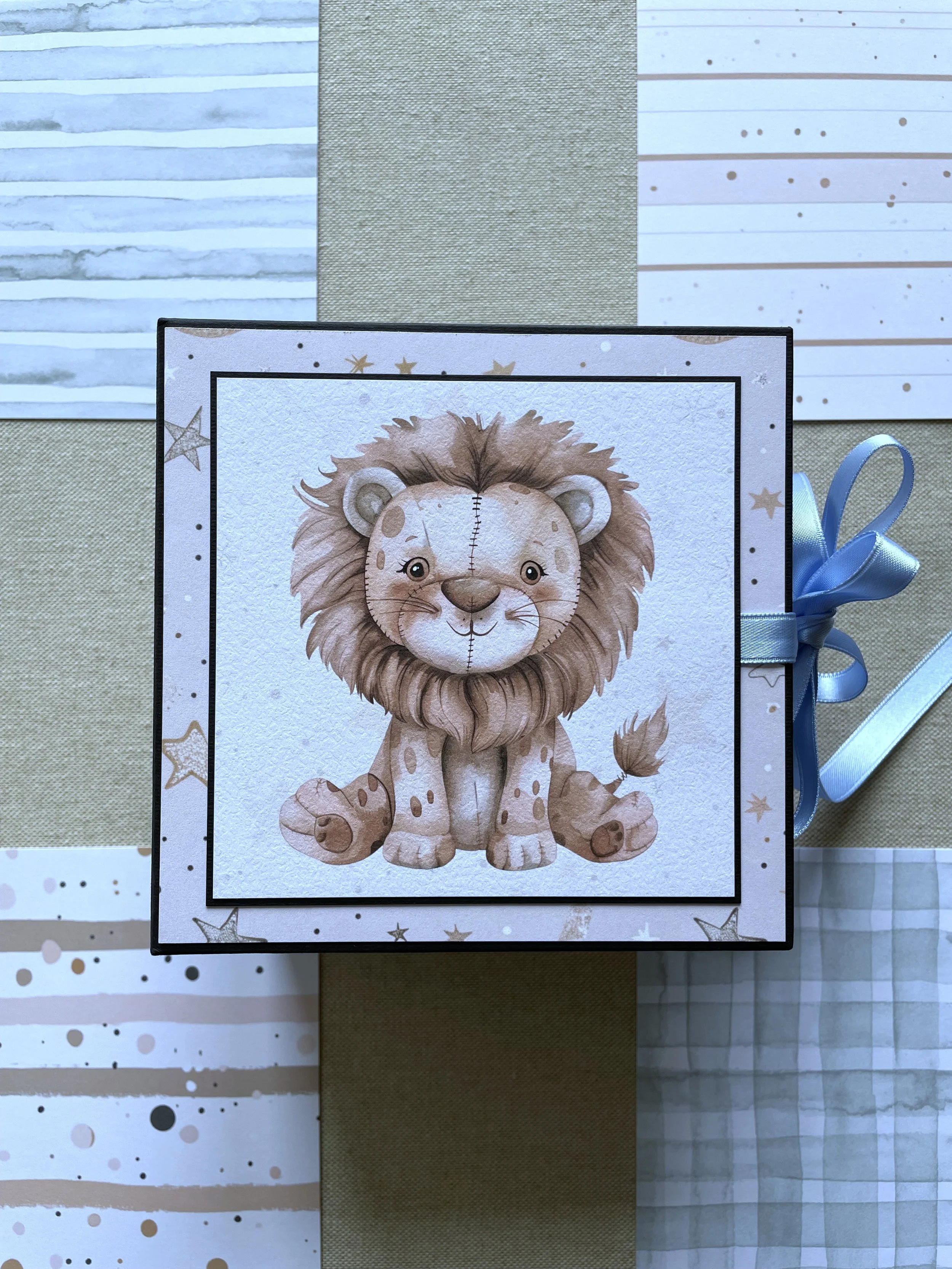 Album per foto, modello Slimmy,  con un'illustrazione di un grosso leone di pezza con una lunga criniera, seduto sorridente. tema animali di pezza. fatto a mano artigianalmente. Regalo nascita, battesimo, per bambini