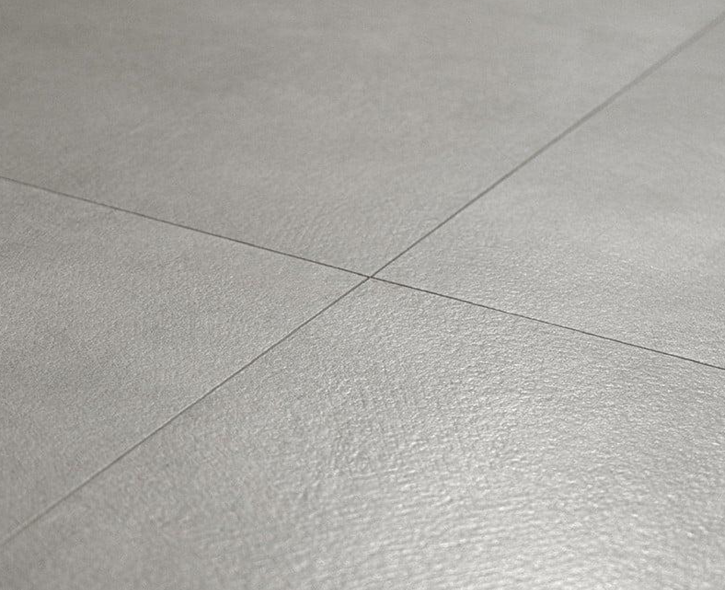 Close-up of large grey porcelain floor tiles with a smooth finish and narrow grout lines.
