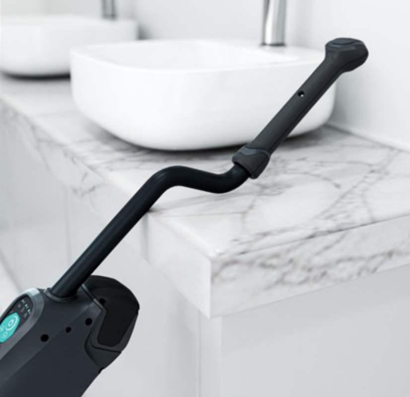 DRYFT resting against a table edge with the bent handle supporting the machine, showing a simple table-stand storage method that helps prevent slipping.
