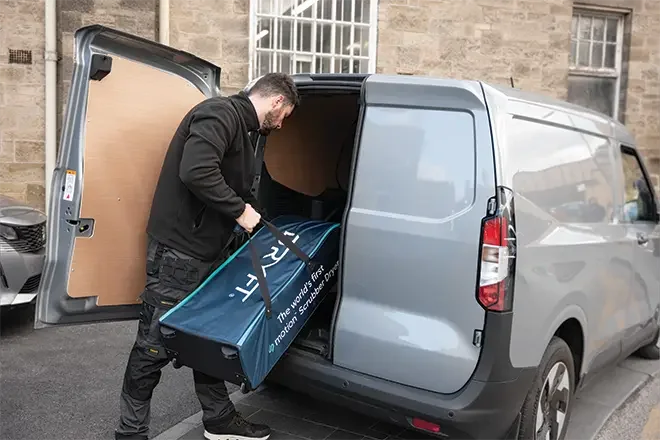 Cleaner loading the DRYFT Case into a van, showing smooth-rolling, protected transport that keeps the kit organised, stable in transit, and ready to deploy fast between sites.