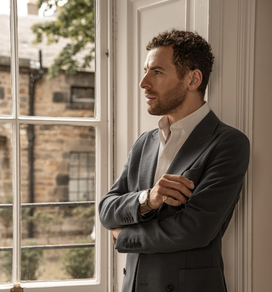 Nathan is a professional photographer & content creator based in Scotland. In this image he is stood beside a window, looking into the distance.