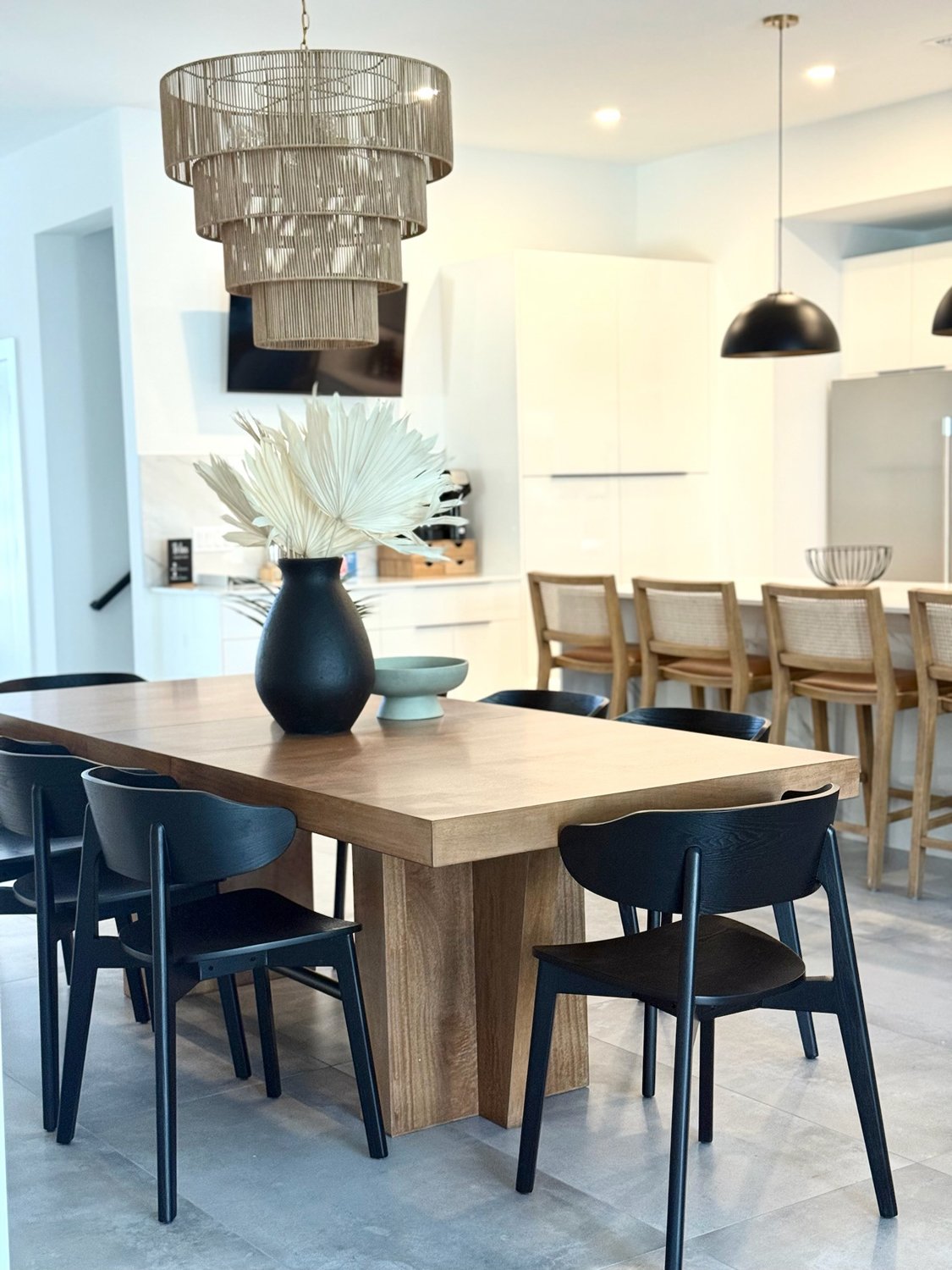 Contemporary-dining-room-table-with-black-chairs-and-natural-tiered-chandelier.jpg