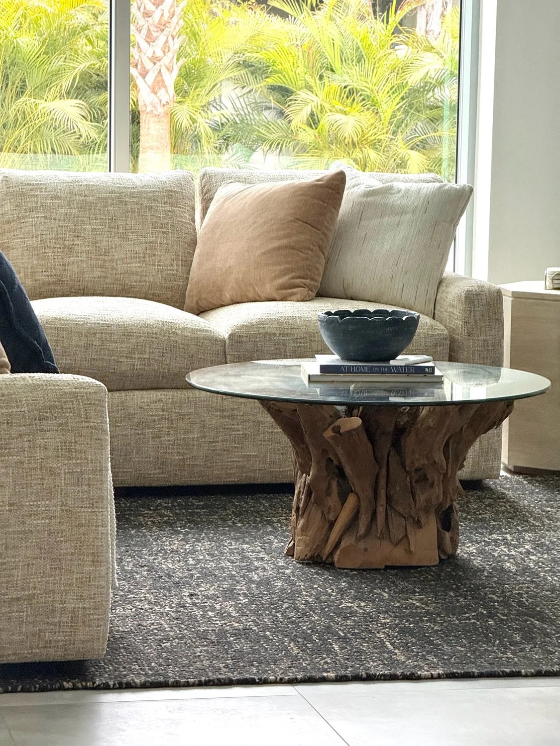 Neutral-couch-with-tree-stump-and-glass-coffee-table.jpg