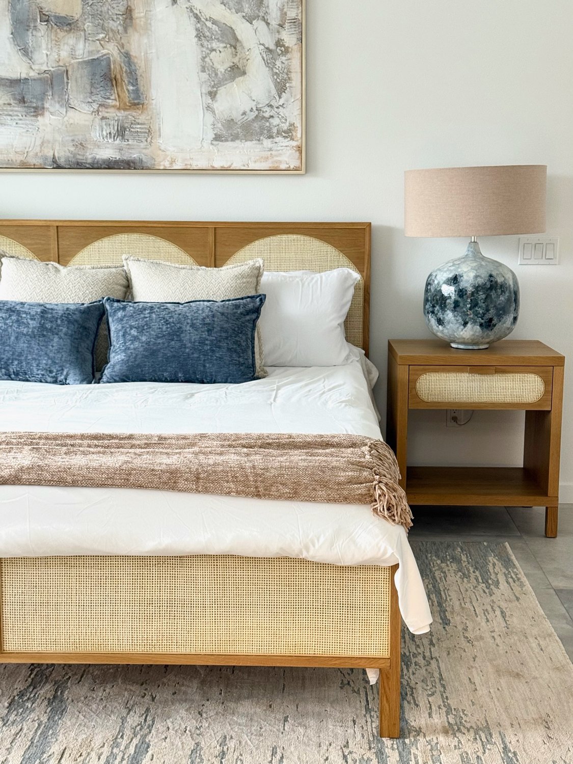 Bed-with-natural-fiber-and-wood-headboard-white-sheets-blue-accent-pillows.jpg