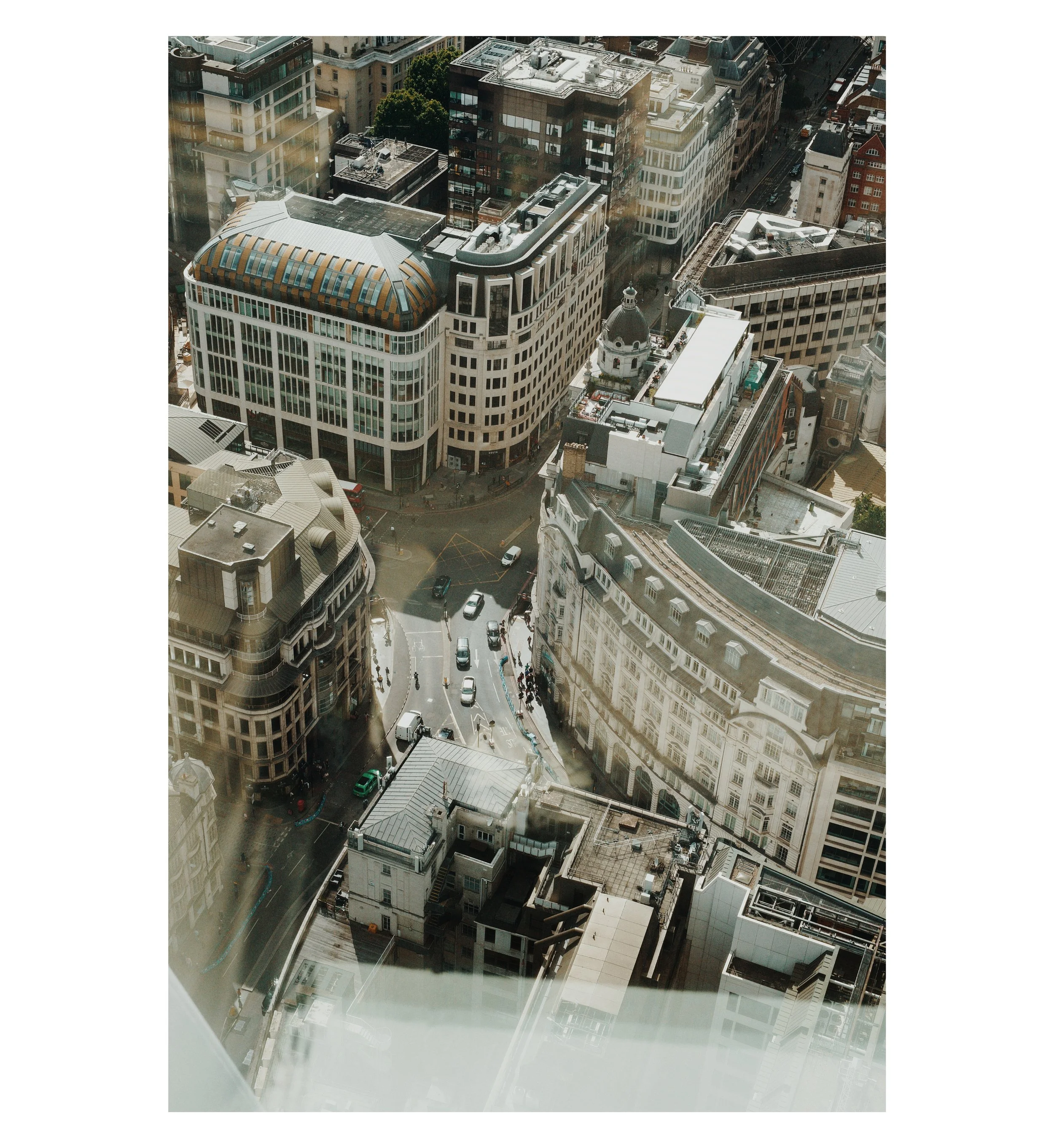 Luftaufnahme einer Stadt mit hohen Gebäuden, Straßen und Autos, die sich in der Innenstadt erstrecken.