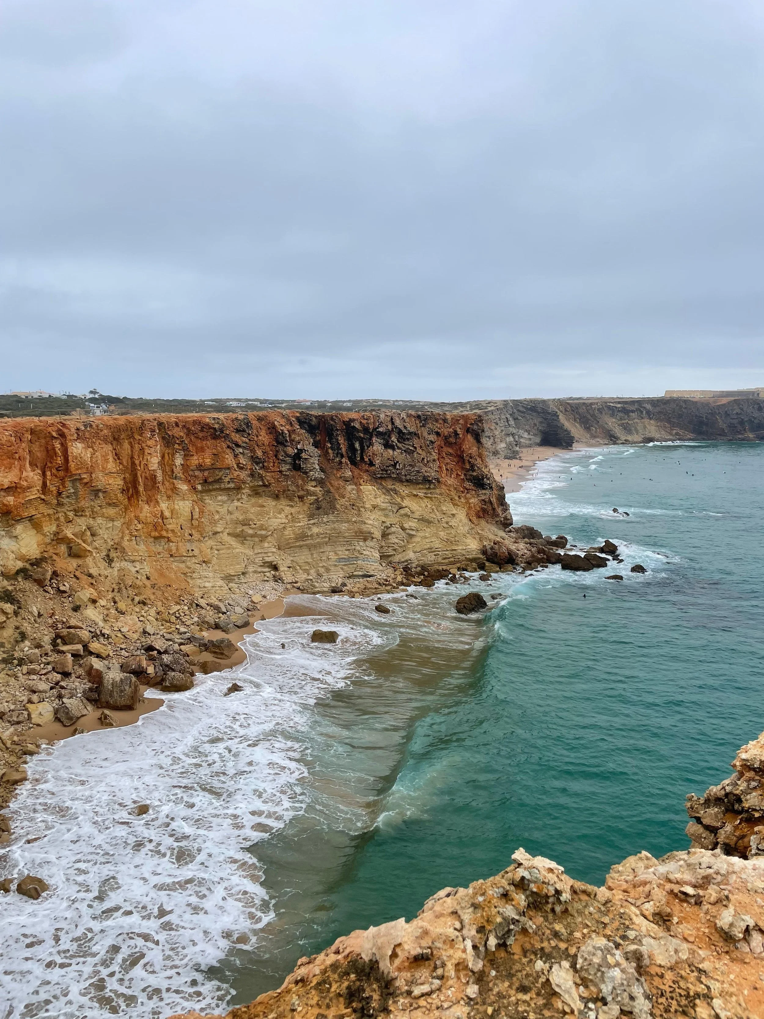 Klippen an der Küste mit Blick auf den Ozean, Wellen schlagen gegen die Felsen bei bewölktem Himmel. Portugal, meer