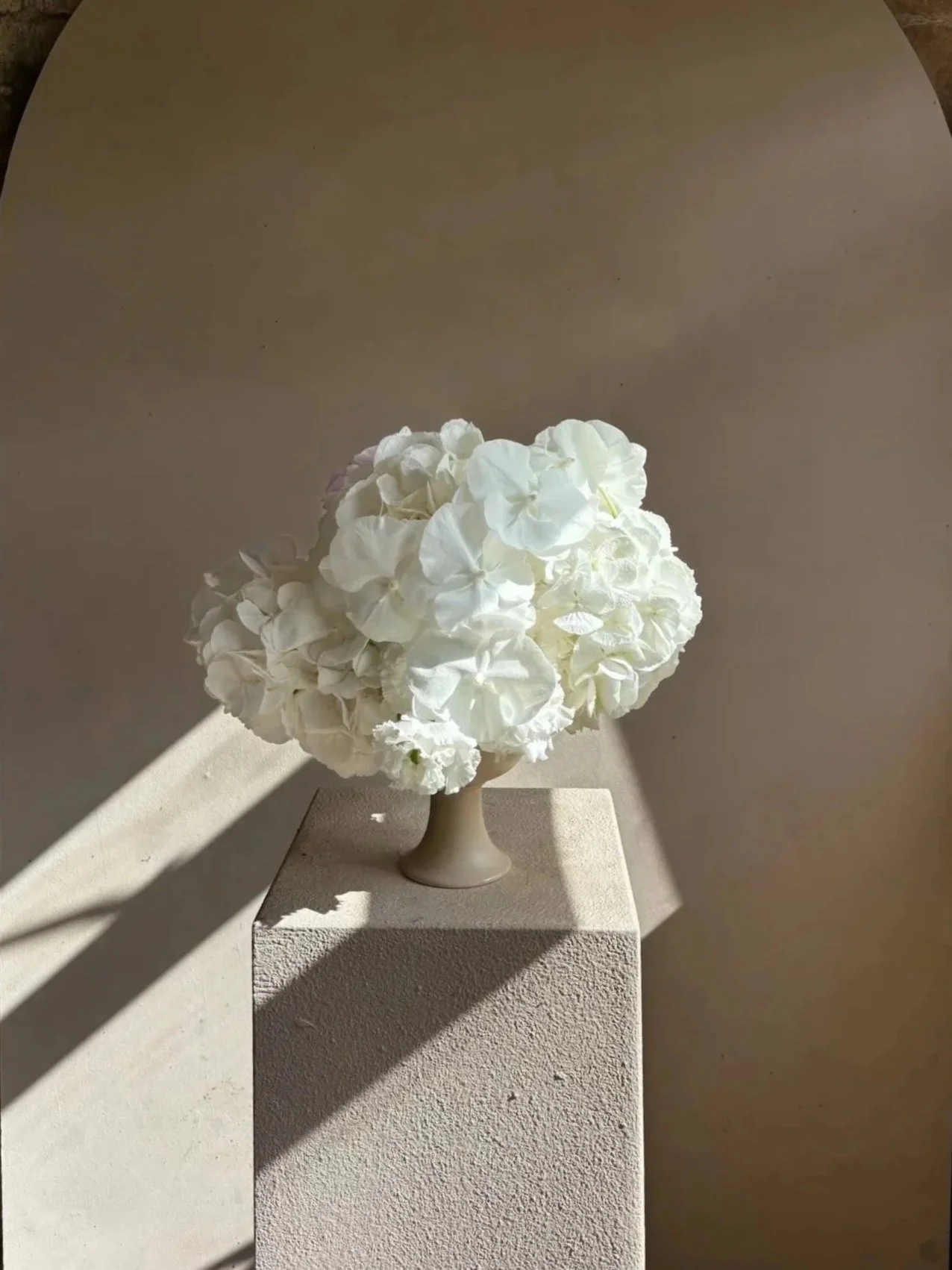 White hydrangea and cascading phalaenopsis orchid wedding centrepiece in a sculptural footed bowl, created for a luxury wedding reception in Bath, Somerset by Florista wedding florist.